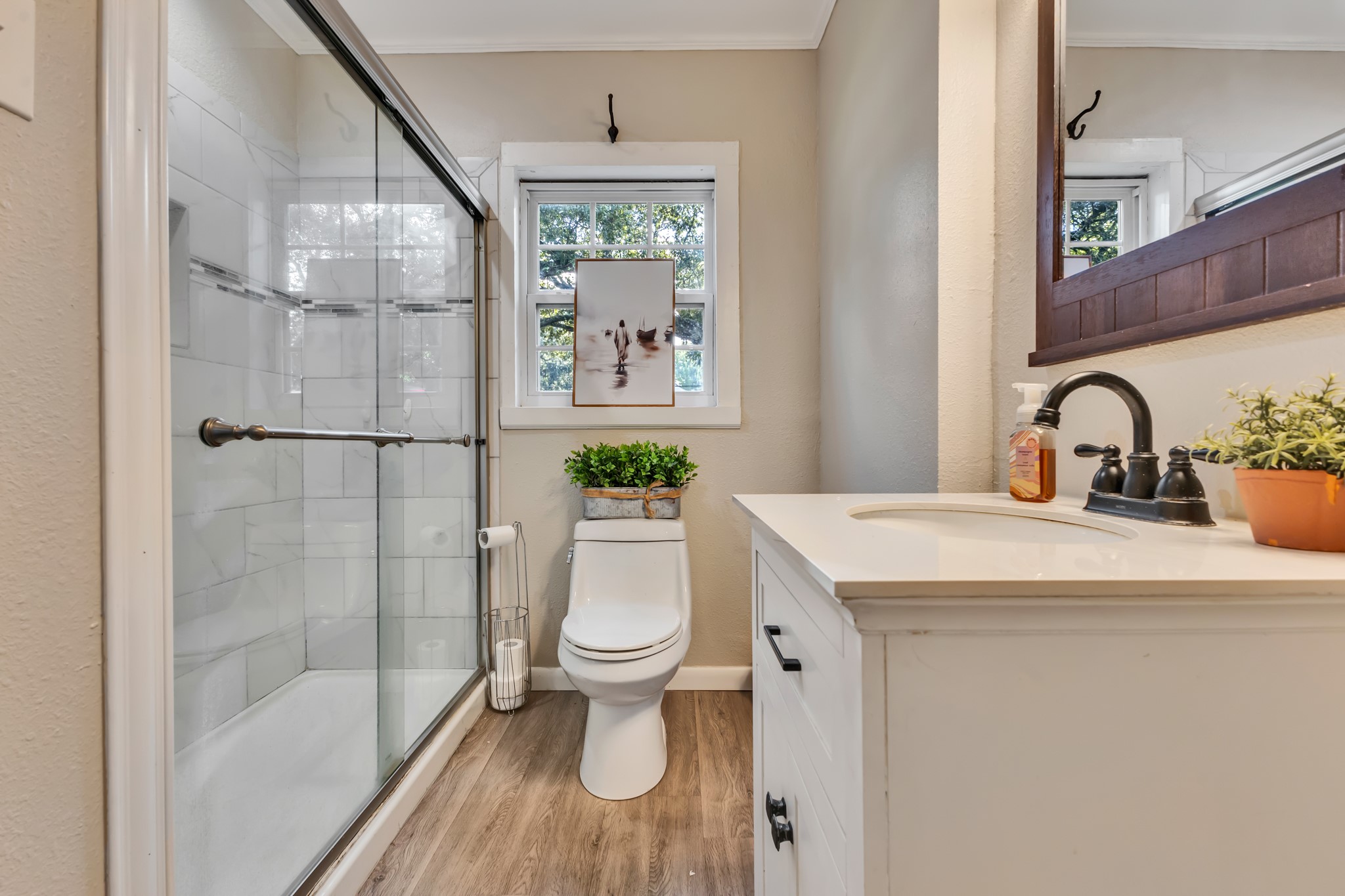 Fresh finishes and a glass-enclosed tiled shower bring modern appeal to this bathroom. The neutral design offers a clean, timeless look that is easy to personalize.