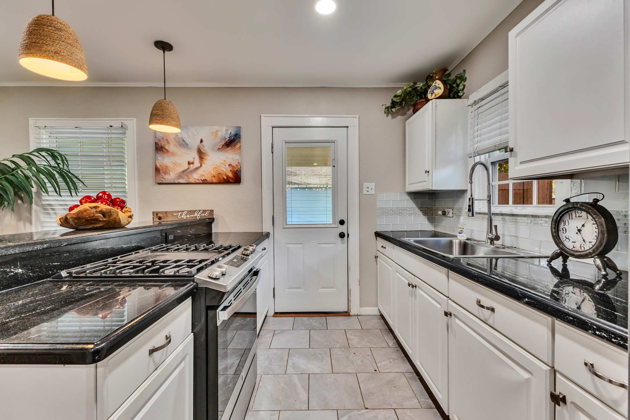 A kitchen that combines style with everyday functionality! White cabinetry, dark countertops, stainless steel appliances, and ample preparation space make cooking and entertaining convenient without sacrificing visual appeal.