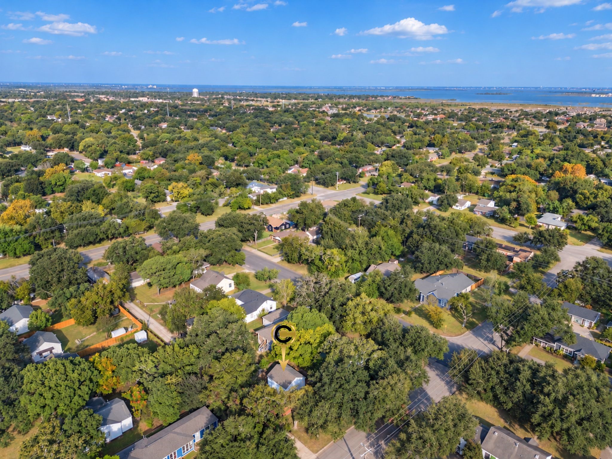 The aerial perspective highlights the home's position among established residential streets and mature greenery. It's an opportunity to enjoy a cozy home in a neighborhood with a distinctly welcoming atmosphere.