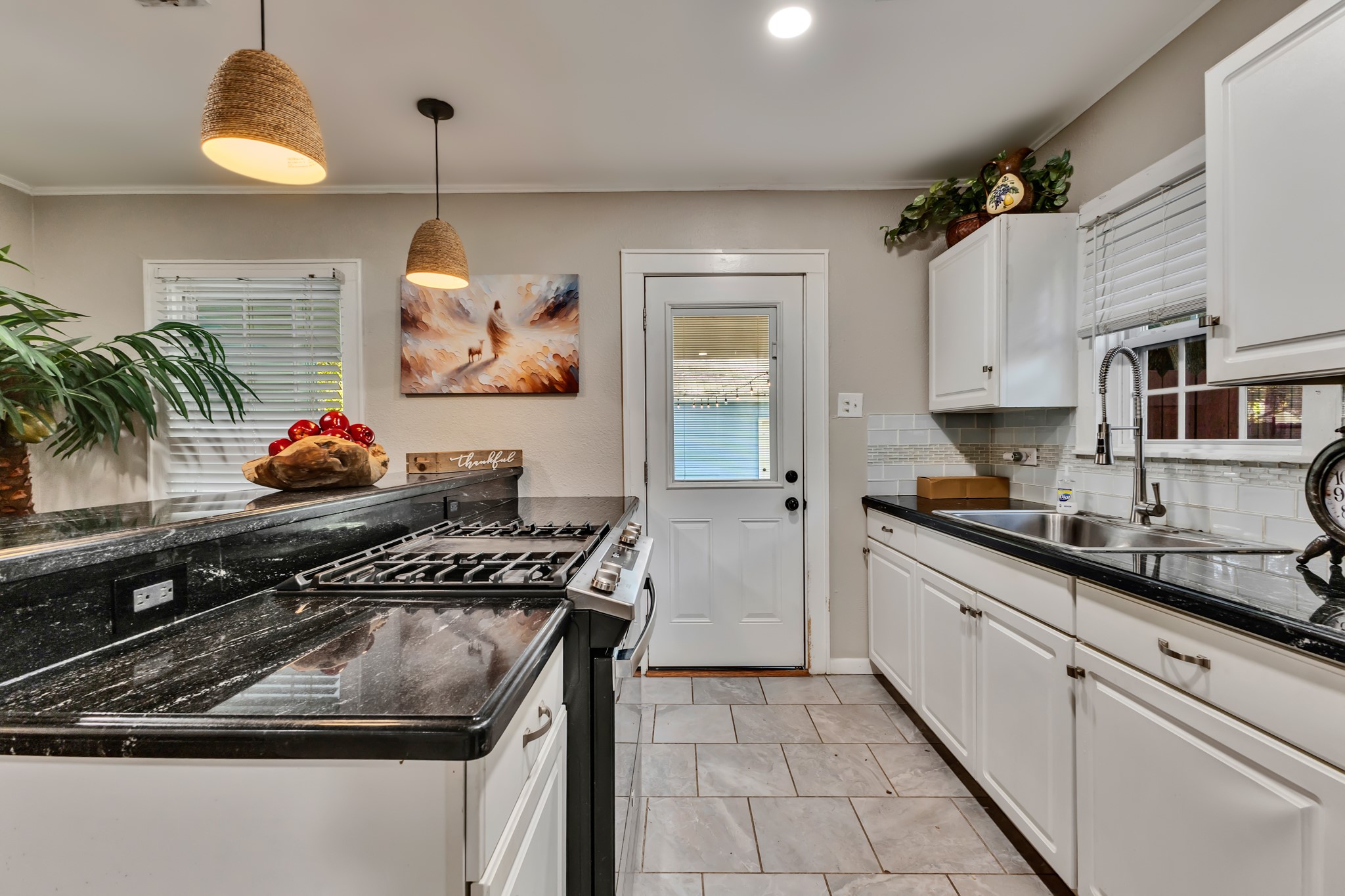 A kitchen designed to make everyday cooking convenient! The combination of white cabinetry, stainless steel appliances, and contrasting countertops creates a polished look while keeping essentials within easy reach.