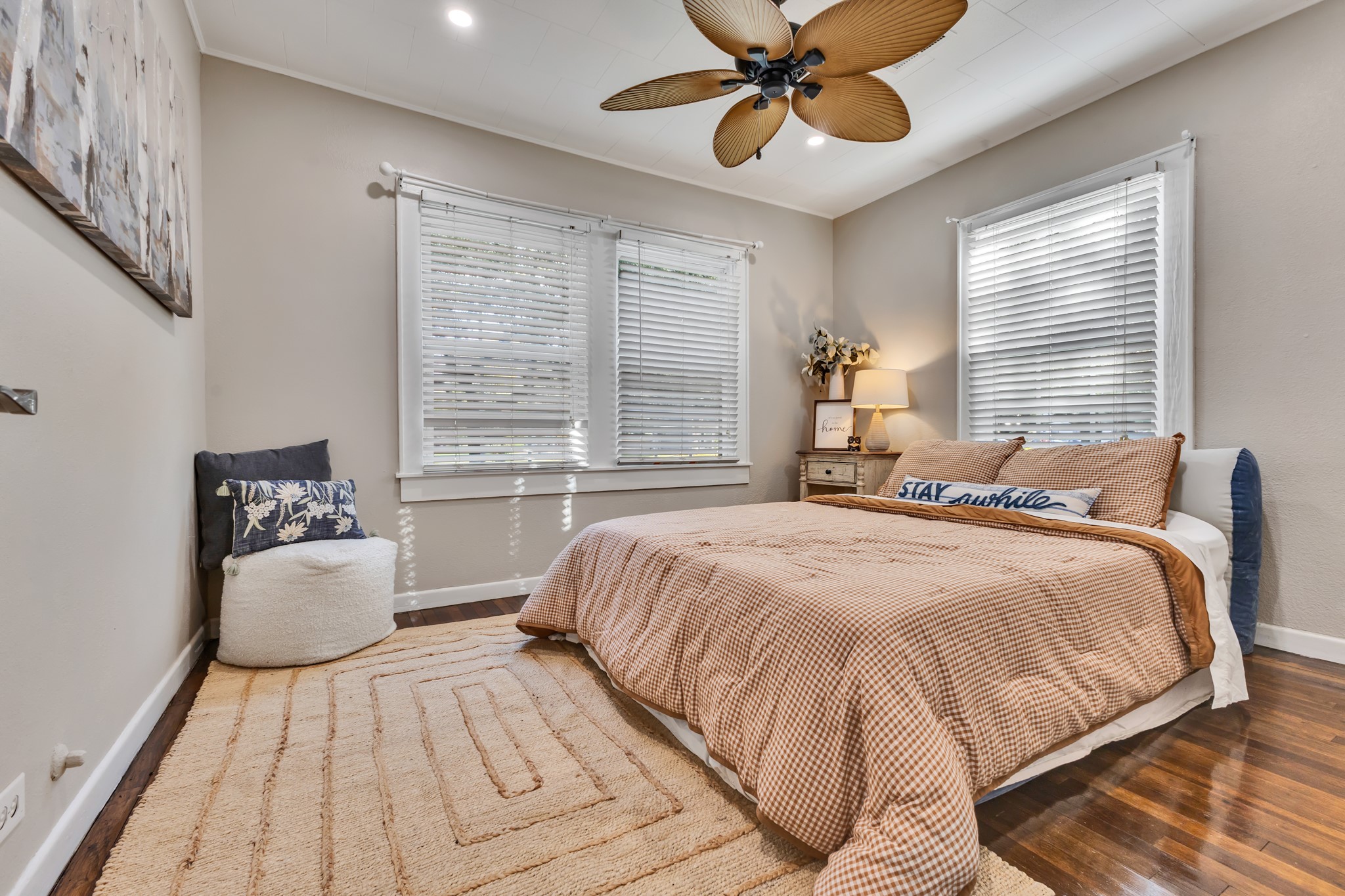 Enjoy a primary bedroom that offers comfort and simplicity. Multiple windows bring in natural light, while the wood flooring adds warmth and timeless character.