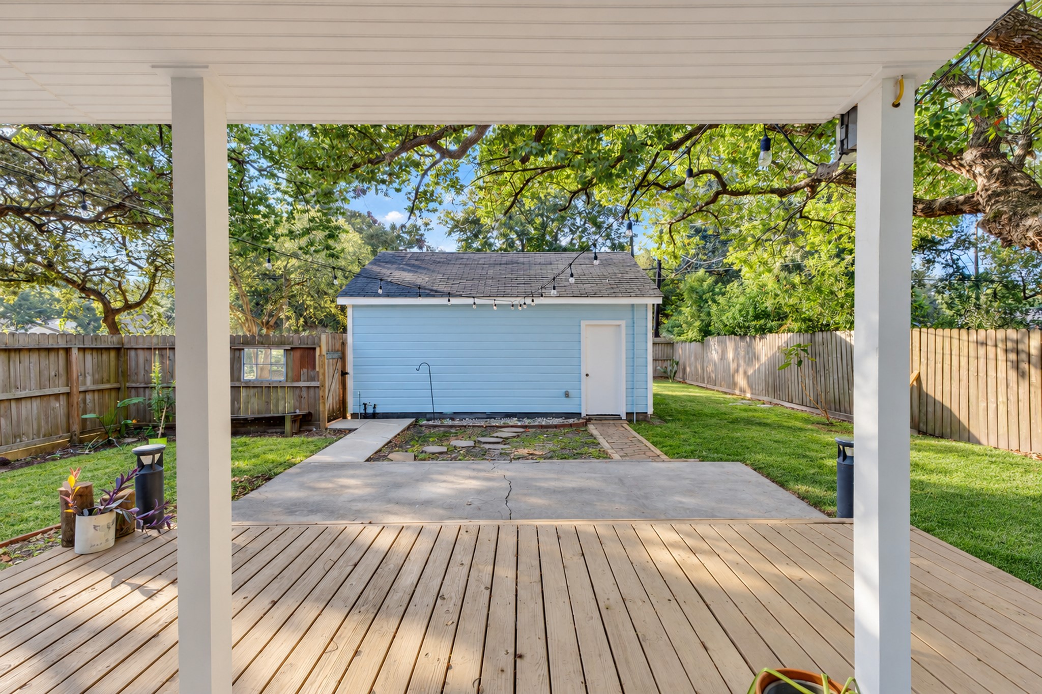 Extend your living space outdoors with this covered area overlooking the backyard. It's an inviting place for morning coffee, outdoor dining, or relaxing in the shade without needing to create an entirely new gathering space.