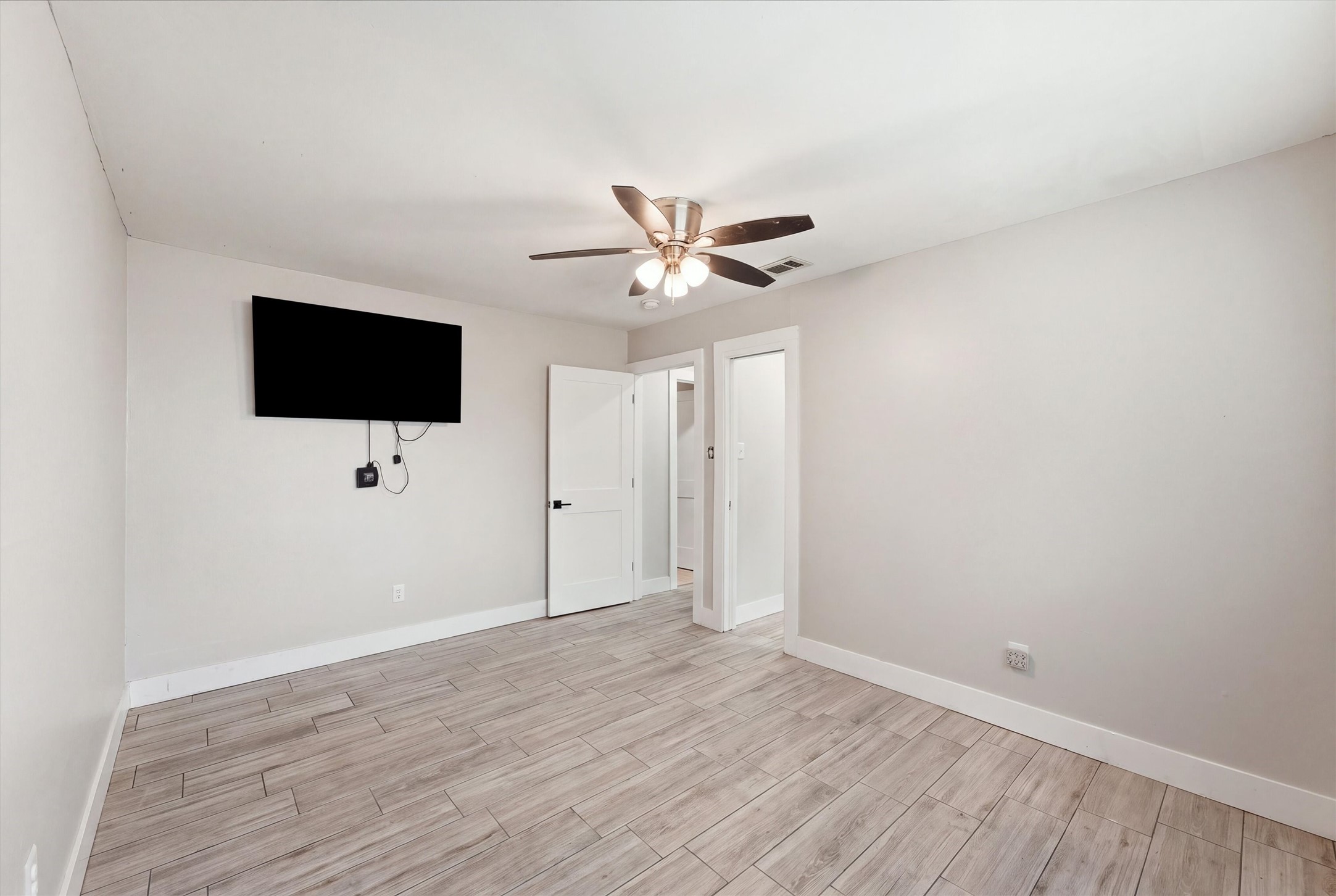 Another view of the third bedroom, showing the neutral finishes, and access to a walk in closet.