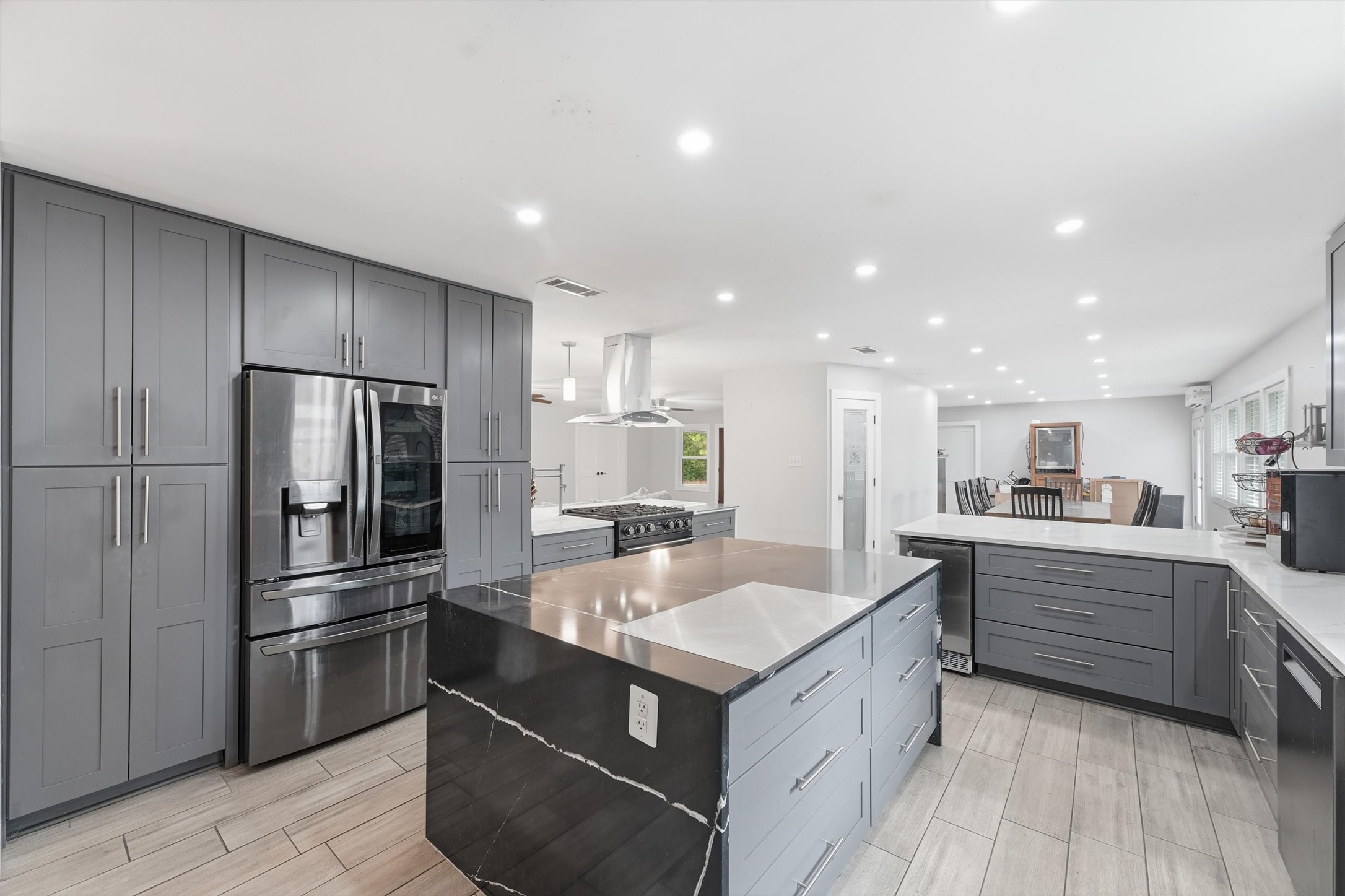 The kitchen includes a center island with additional storage, floor-to-ceiling cabinetry, stainless steel refrigerator, updated appliances, and a pantry conveniently located near the adjoining dining/breakfast area.