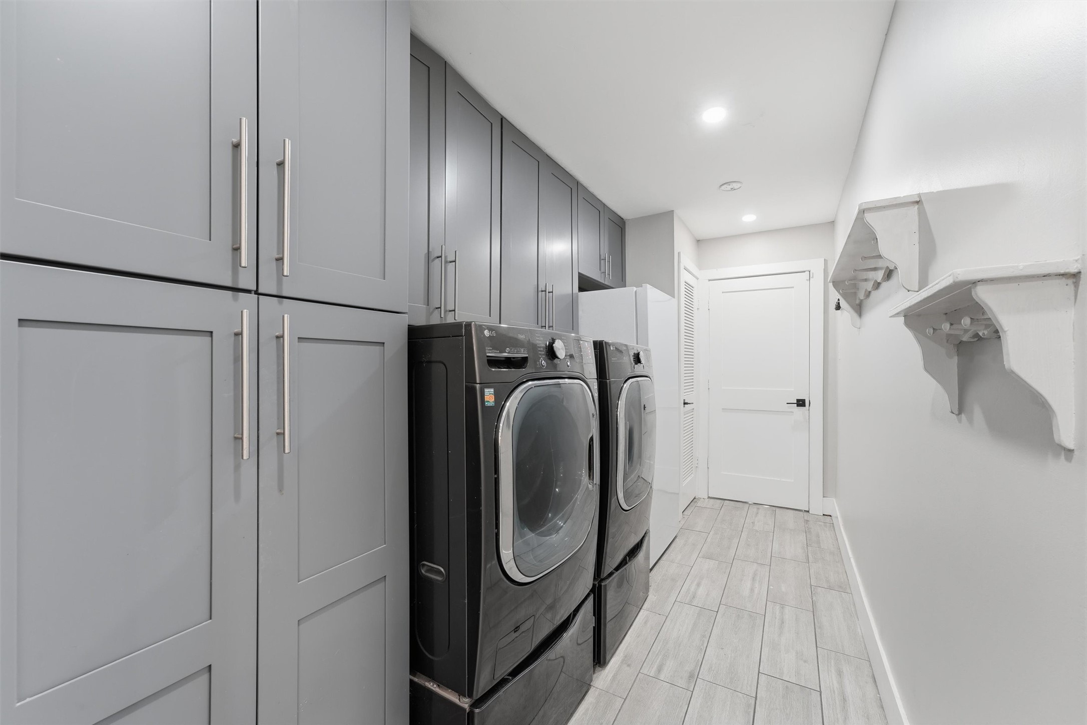 The laundry room offers floor-to-ceiling cabinetry, additional overhead storage, and room for a full-size washer and dryer.