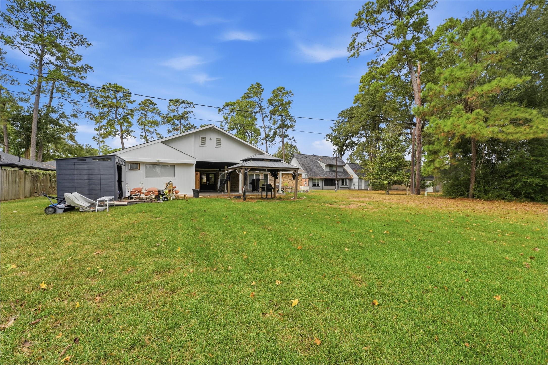 Another view from the back of the property highlights the large backyard and open lawn. With plenty of room for recreation or future outdoor improvements, this backyard offers a variety of possibilities.