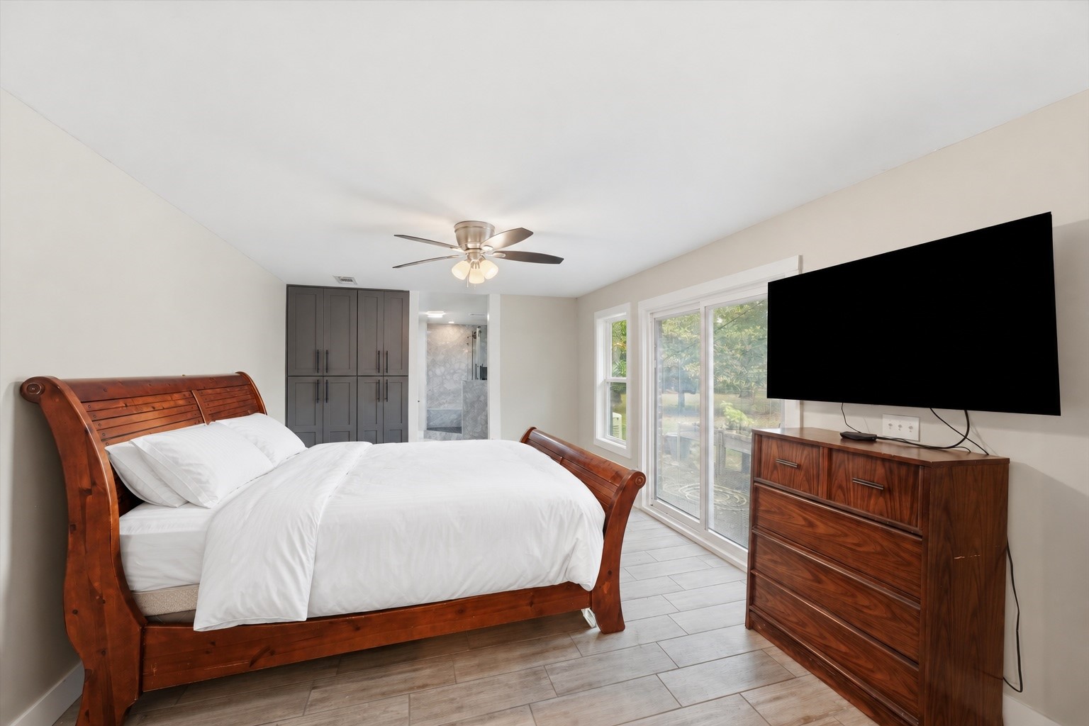 The second primary suite offers a comfortable amount of space, large sliding doors for natural light, and a private bathroom, making it a practical option for extended household living.