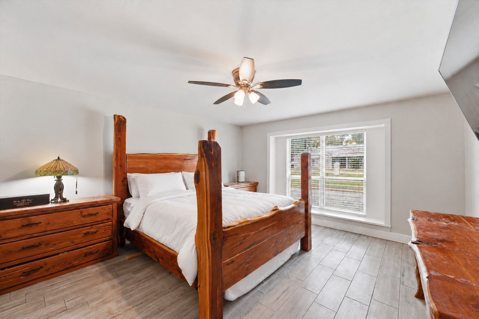 The main primary suite offers an expansive layout with wood-like tile flooring and plenty of room to create a comfortable, relaxing retreat.