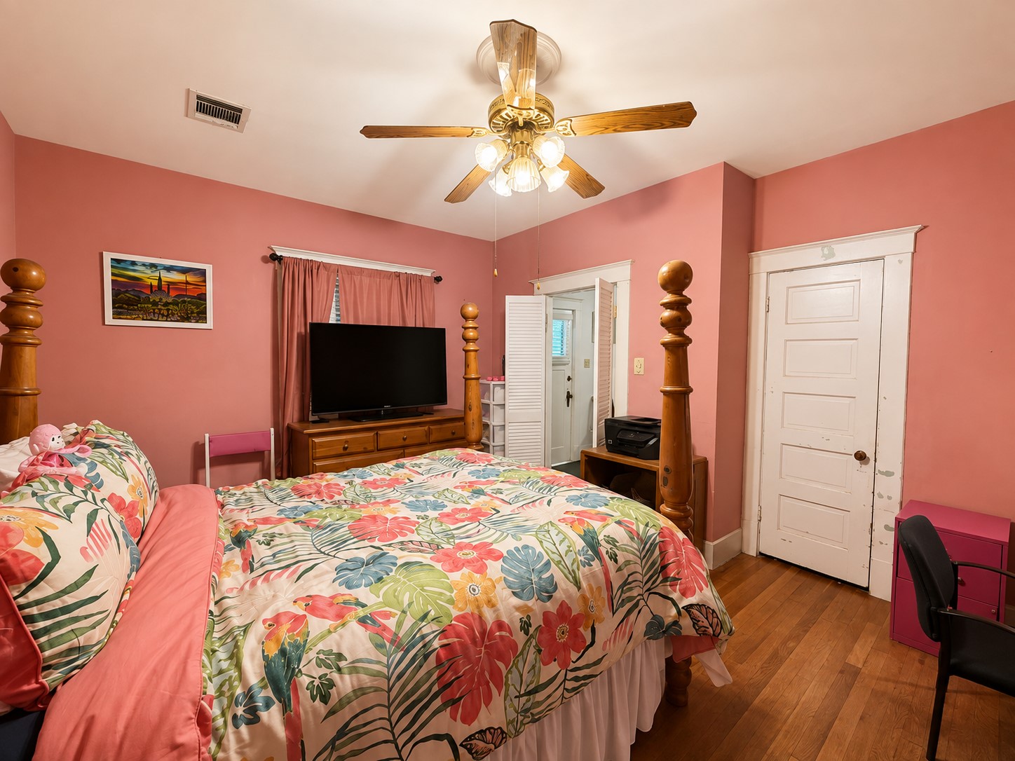 This angle highlights the rooms flexible layout, traditional paneled doors and trim, and warm wood flooring, with multiple access points connecting to adjoining areas.
