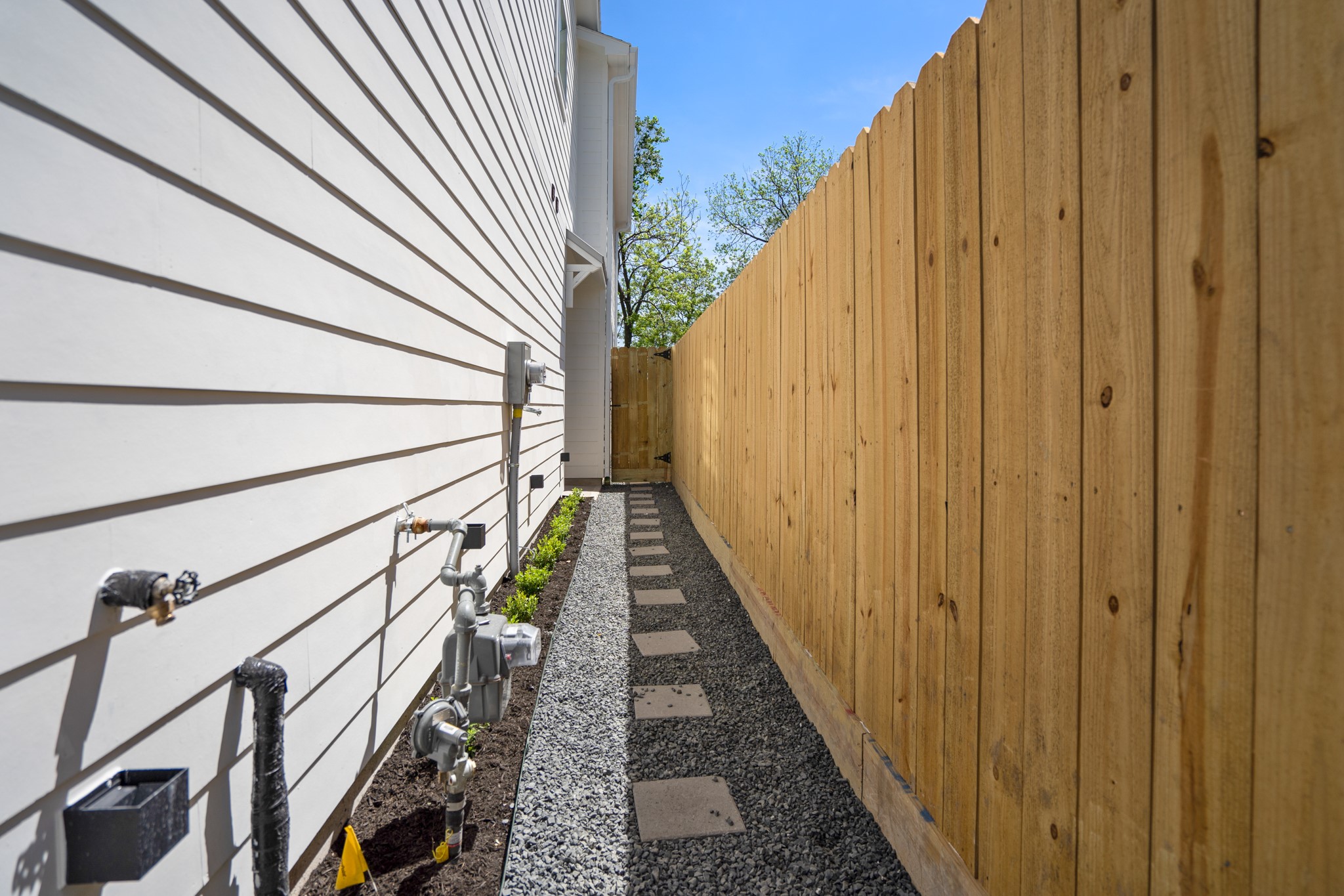 The side of the house walkway serves as a functional access point, connecting different areas of the property with ease and convenience. Photos are of previous model home.