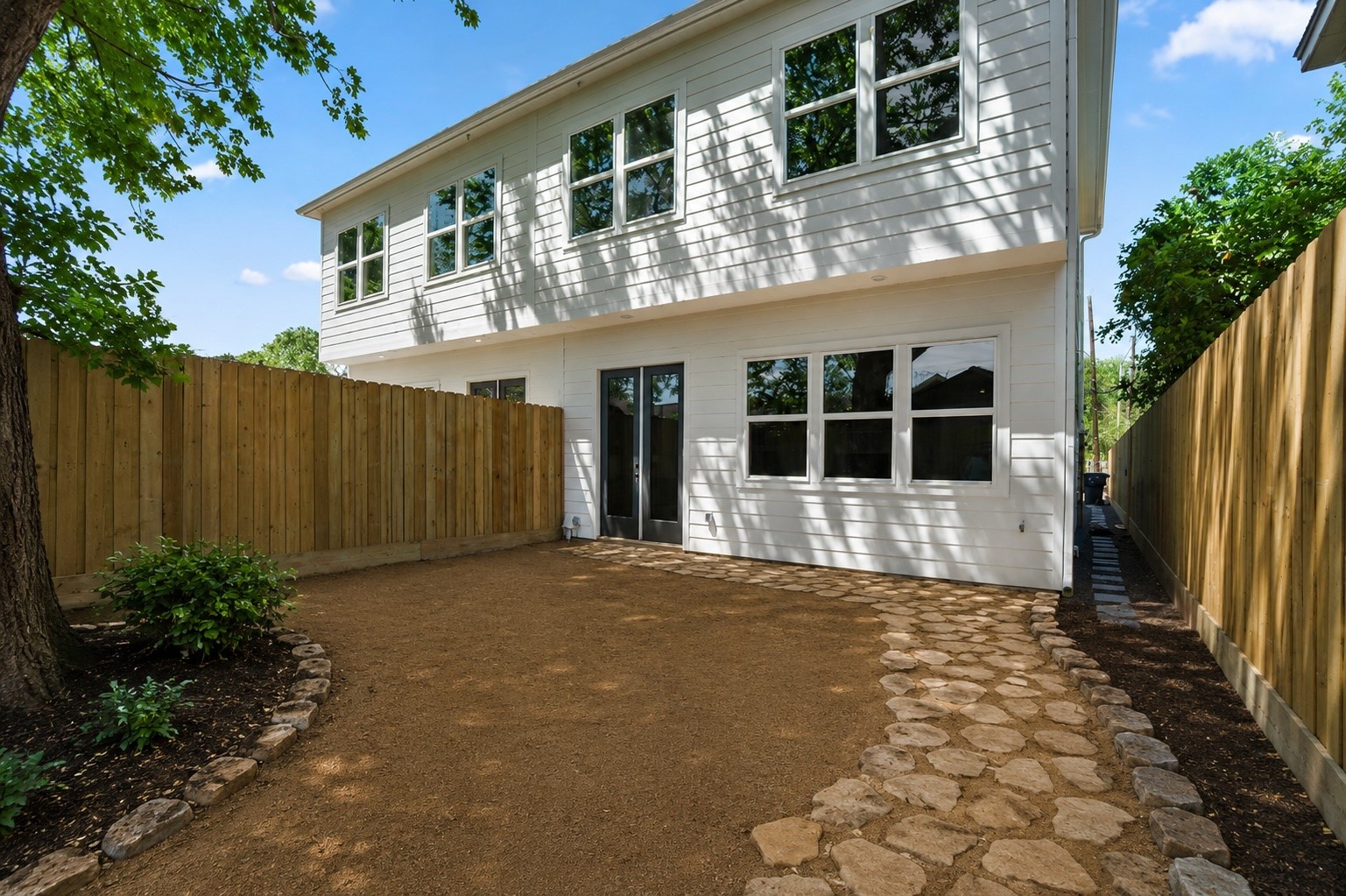 the yard unfolds as a tranquil retreat, enveloped in privacy and serenity.