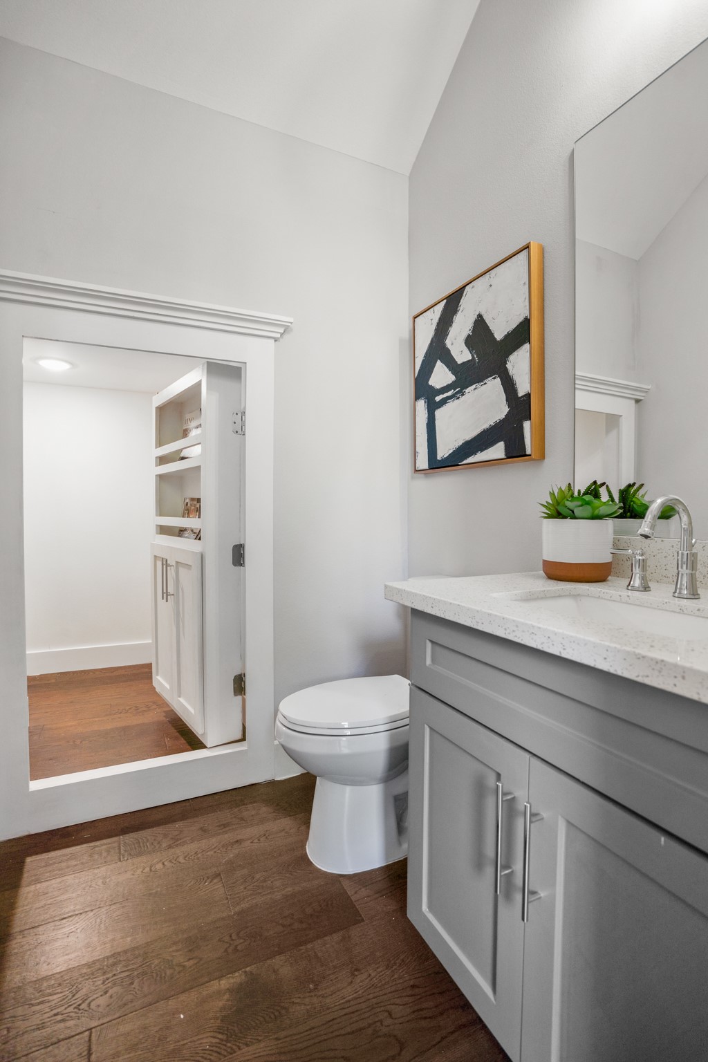 Tucked away behind a discreet panel lies a hidden storage closet within the half bath, providing a clever solution for stowing away essentials while maintaining a clean and uncluttered space. Photos are of previous model home.
