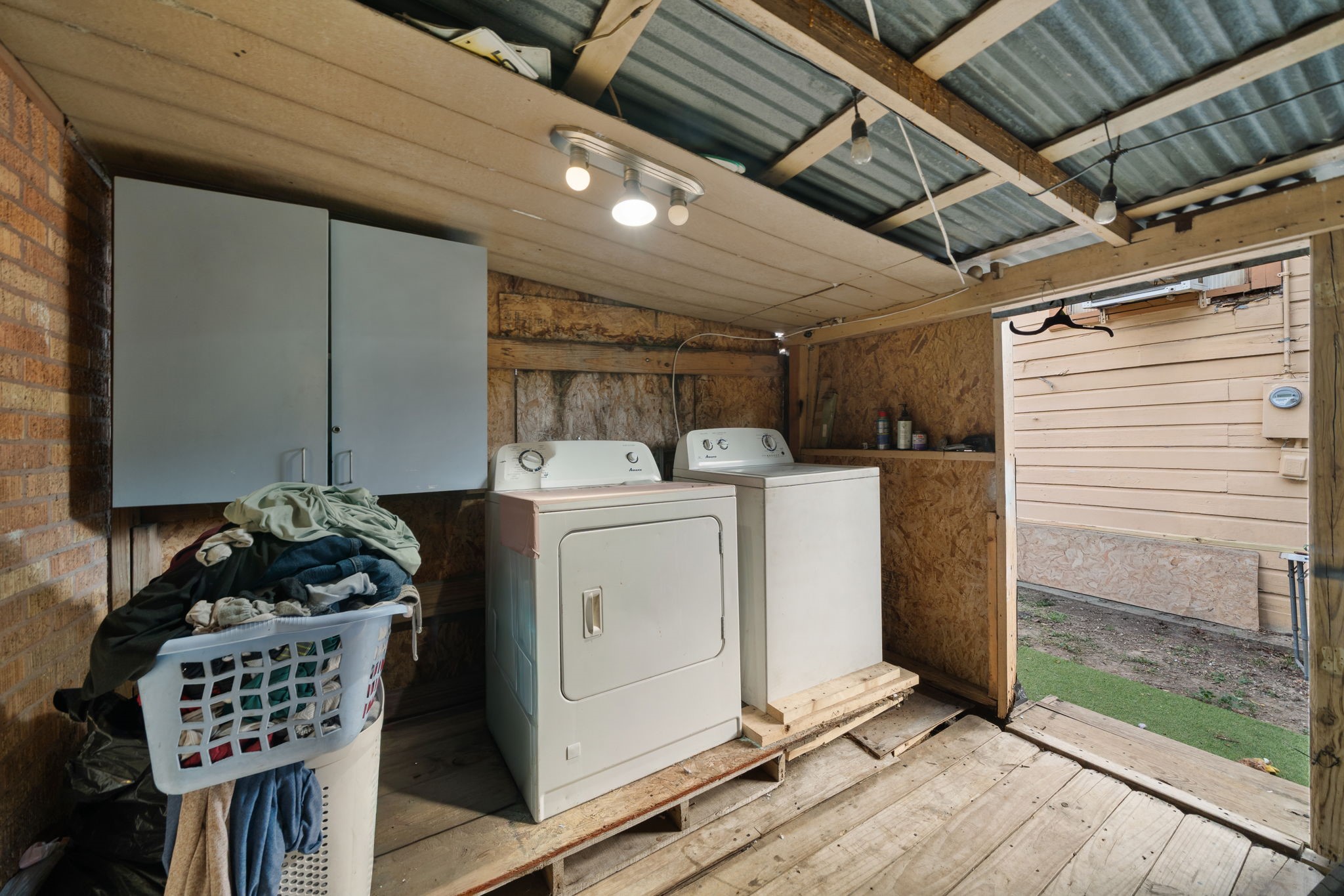 Covered washer and dryer area with lots of storage.