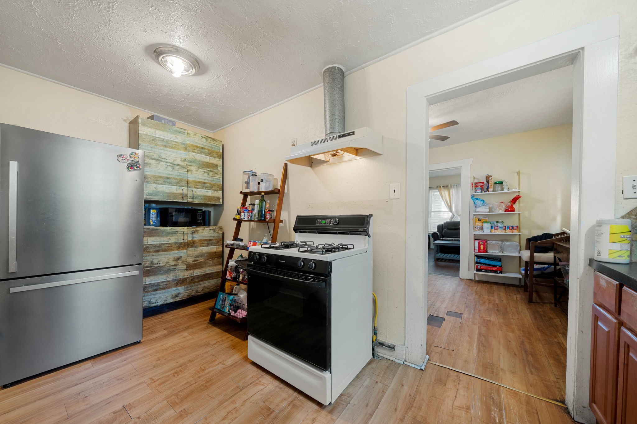 Large kitchen with a gas stove and natural lighting and laminate flooring