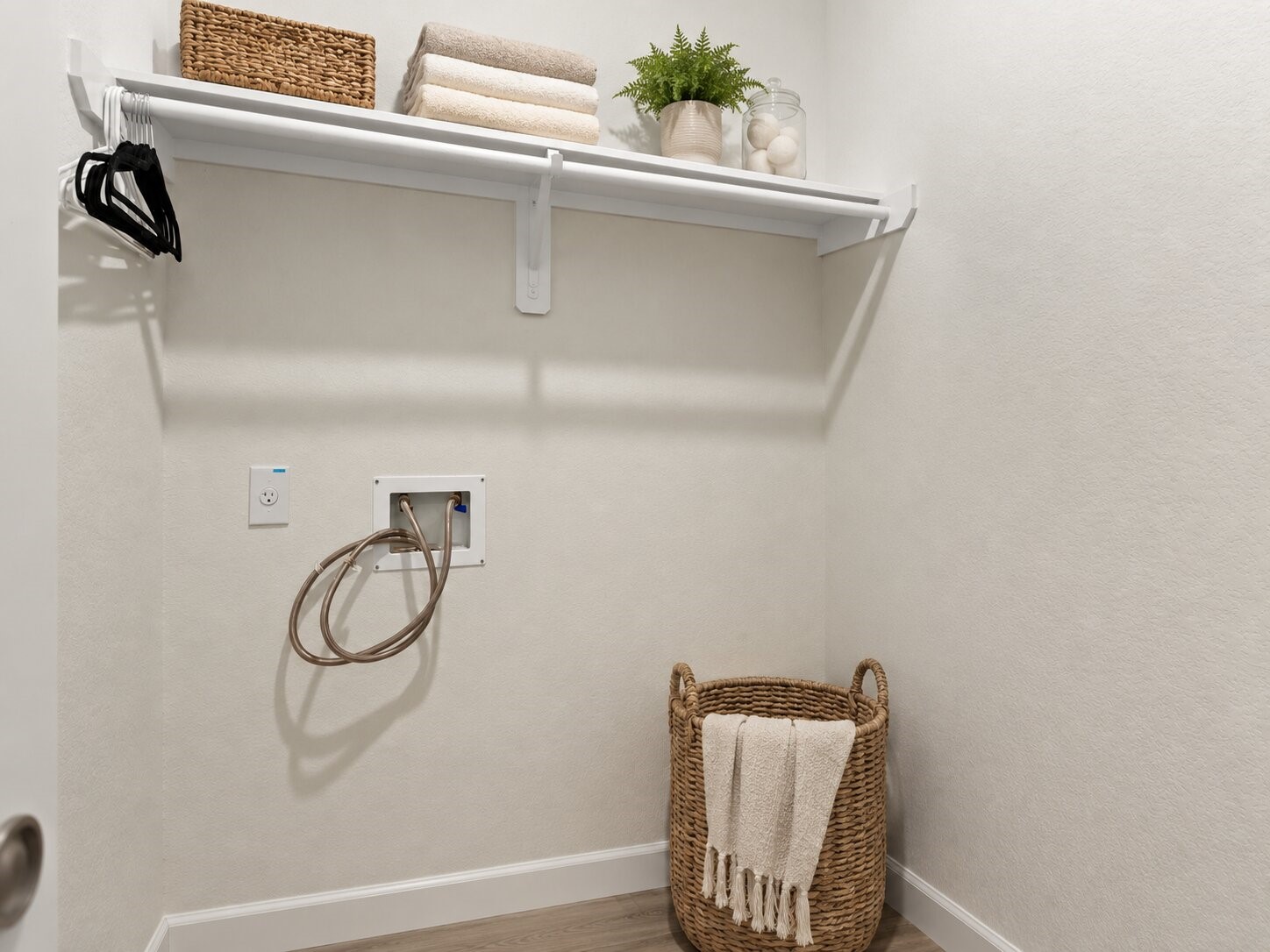 *virtually staged* The dedicated laundry room includes built in shelving for household supplies and additional storage.