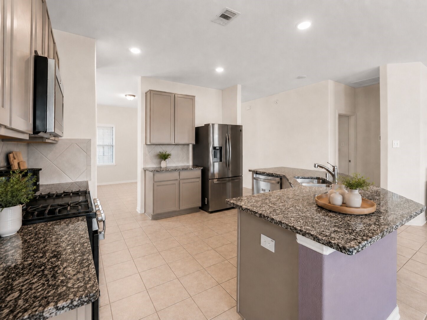 *virtually staged* The kitchen features granite countertops, abundant cabinetry, stainless steel appliances, and a spacious center island.