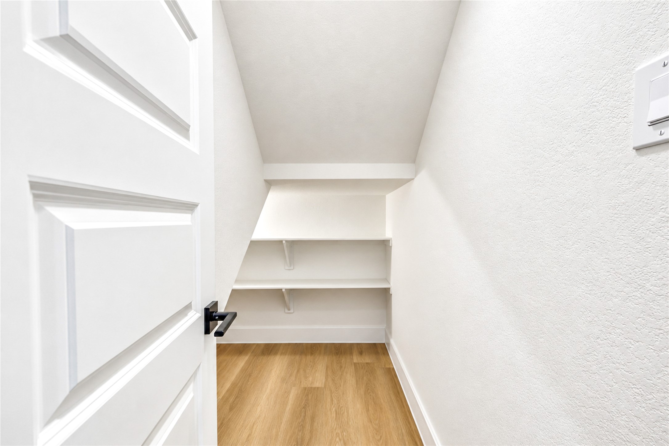 Under-stair storage with shelving.