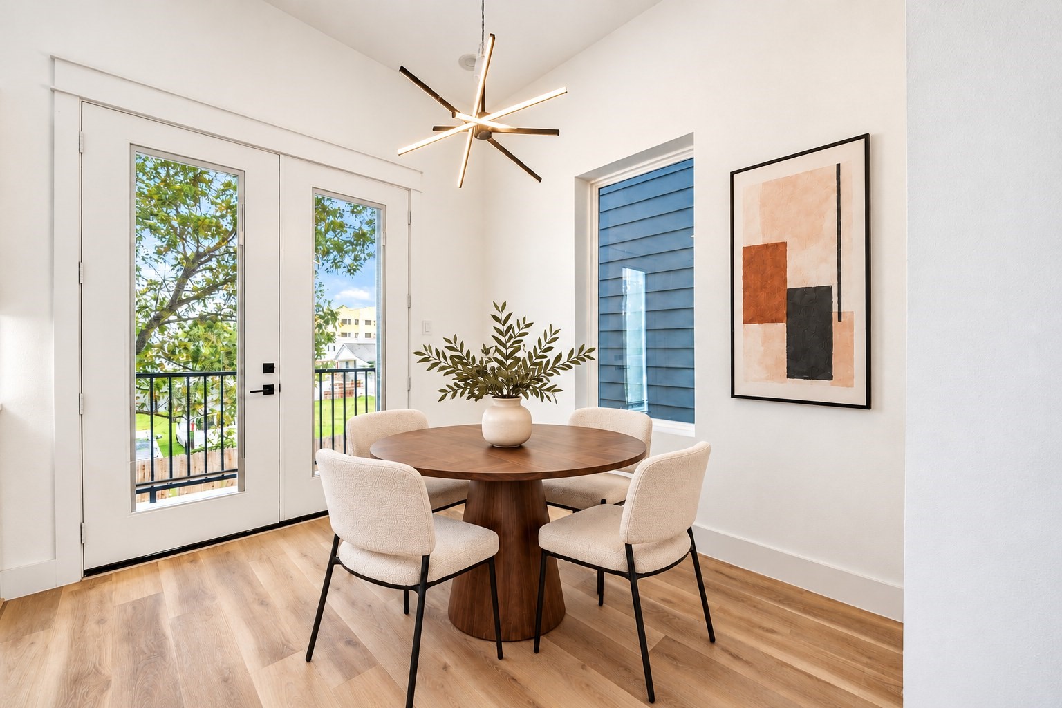 Dining nook with modern lighting, wide-plank flooring, and abundant natural light. *Virtually staged