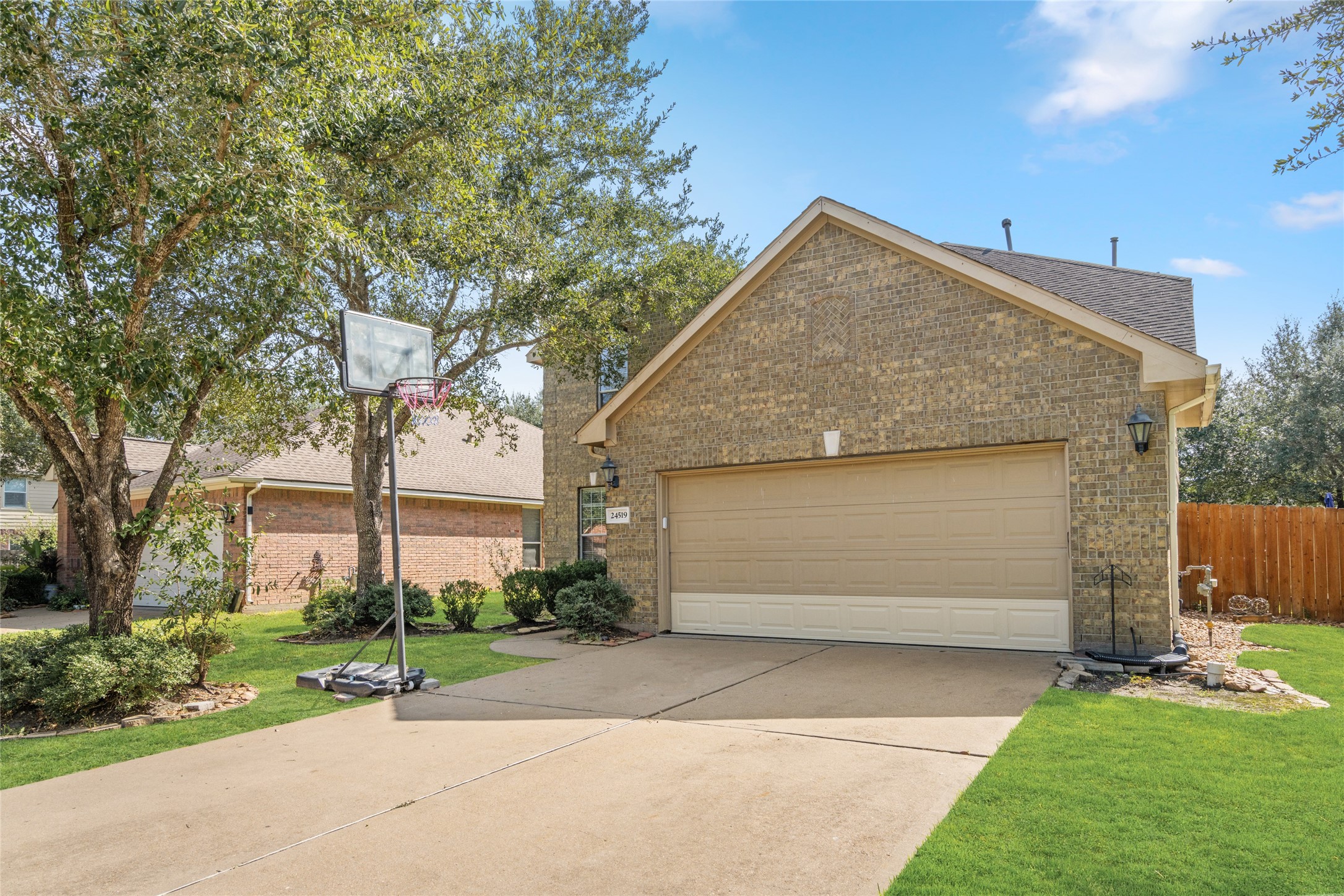 Attractive brick exterior featuring a spacious two-car garage, extended driveway, and landscaped front yard. The driveway provides convenient off-street parking for residents and guests.