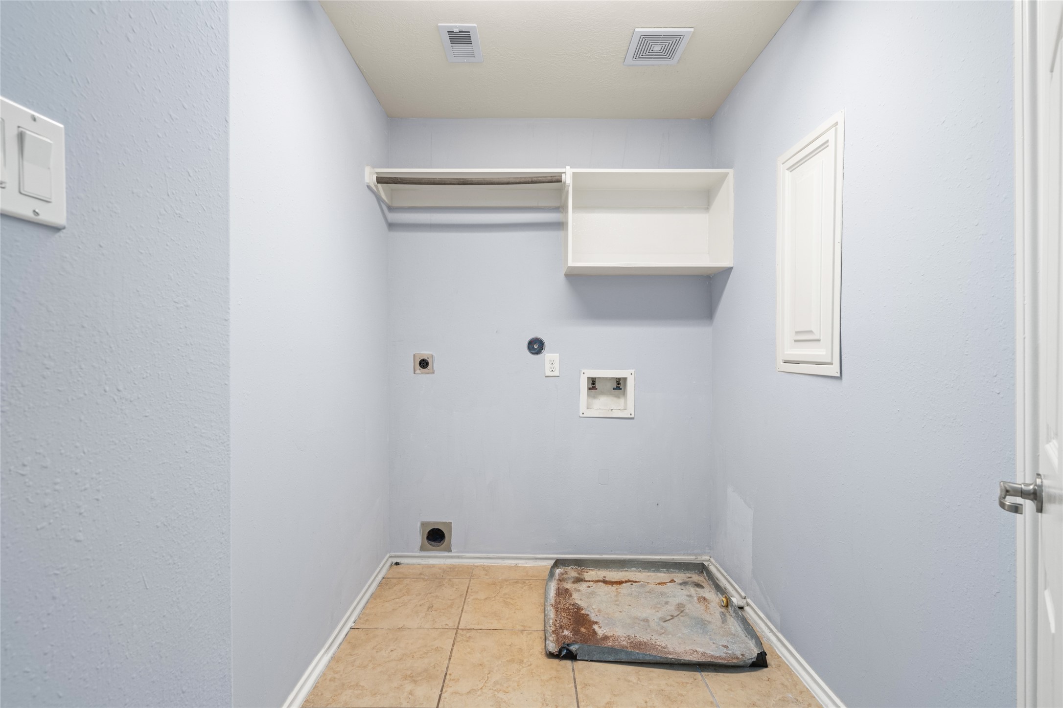 Dedicated utility and laundry room with space for laundry appliances, wall-mounted storage, and everyday laundry supplies. Keeping laundry in a separate room helps organize household chores and frees up space in the main living areas.