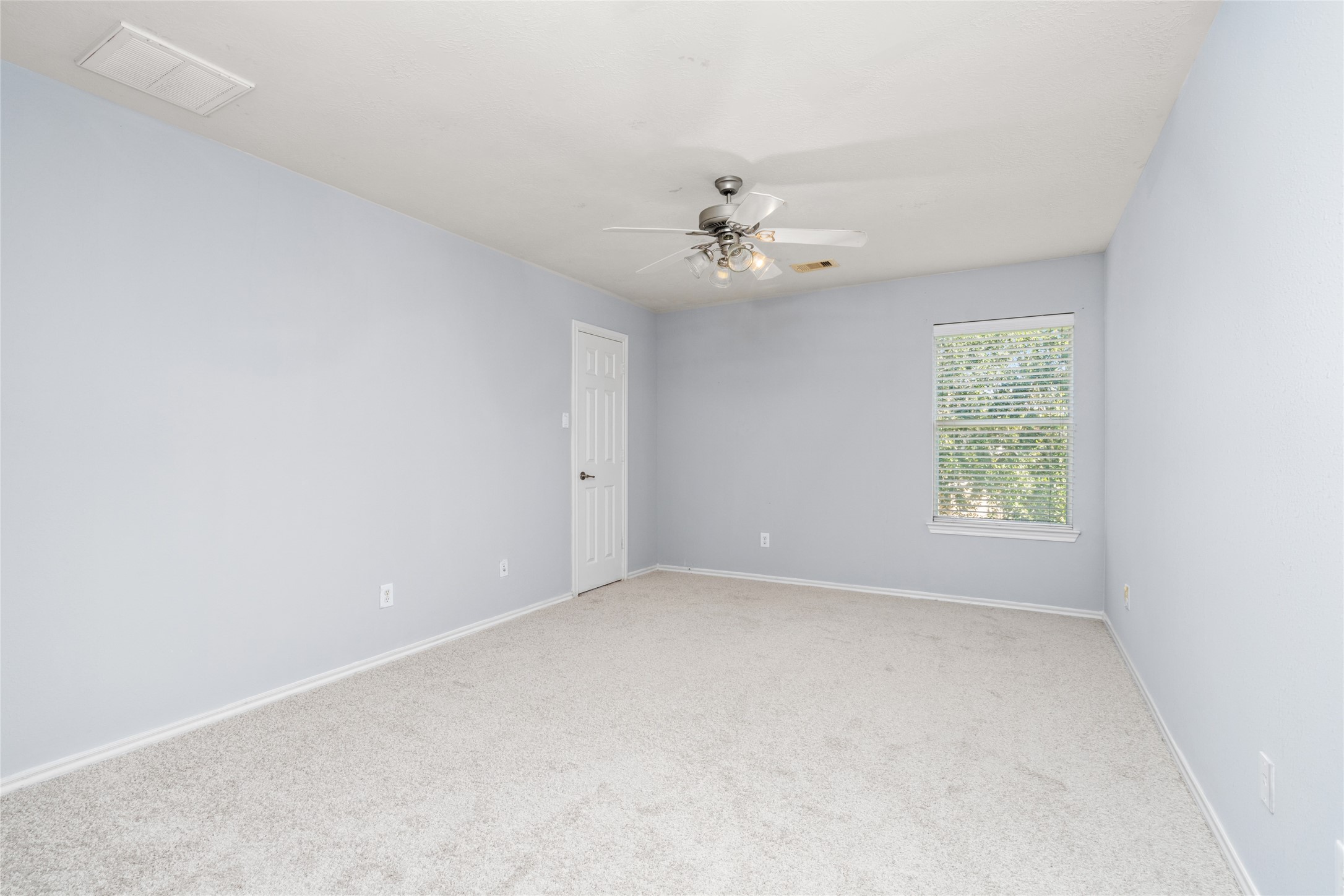 Spacious secondary bedroom featuring soft carpeting, a ceiling fan, and a window that brings in natural light. The simple, open layout makes it easy to personalize the room for sleeping, studying, or other everyday needs.