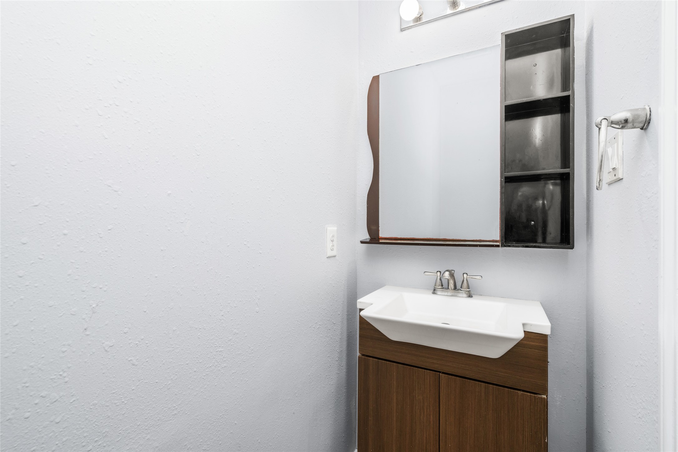 Convenient first-floor half bathroom featuring a modern vanity, mirror, and neutral finishes. Its location near the main living areas provides practical access for household members and visiting guests.