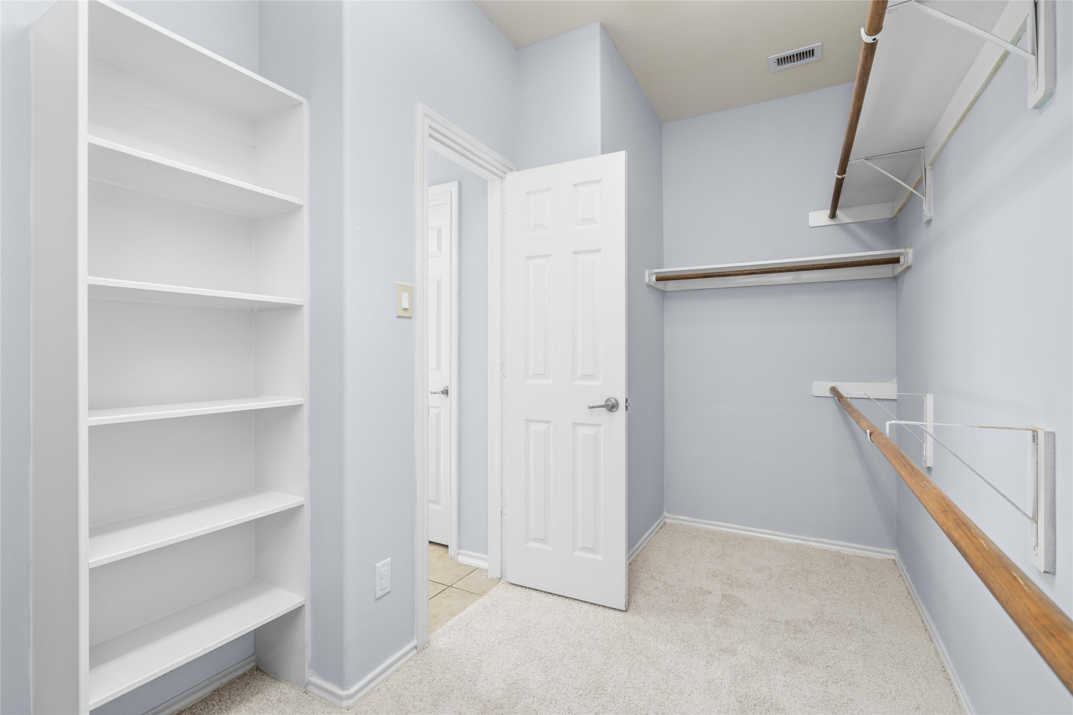 Walk-in closet with built-in shelving, hanging space, and a practical layout for organizing clothing, shoes, and accessories. The dedicated storage area helps keep the primary bedroom uncluttered and everyday essentials within reach.