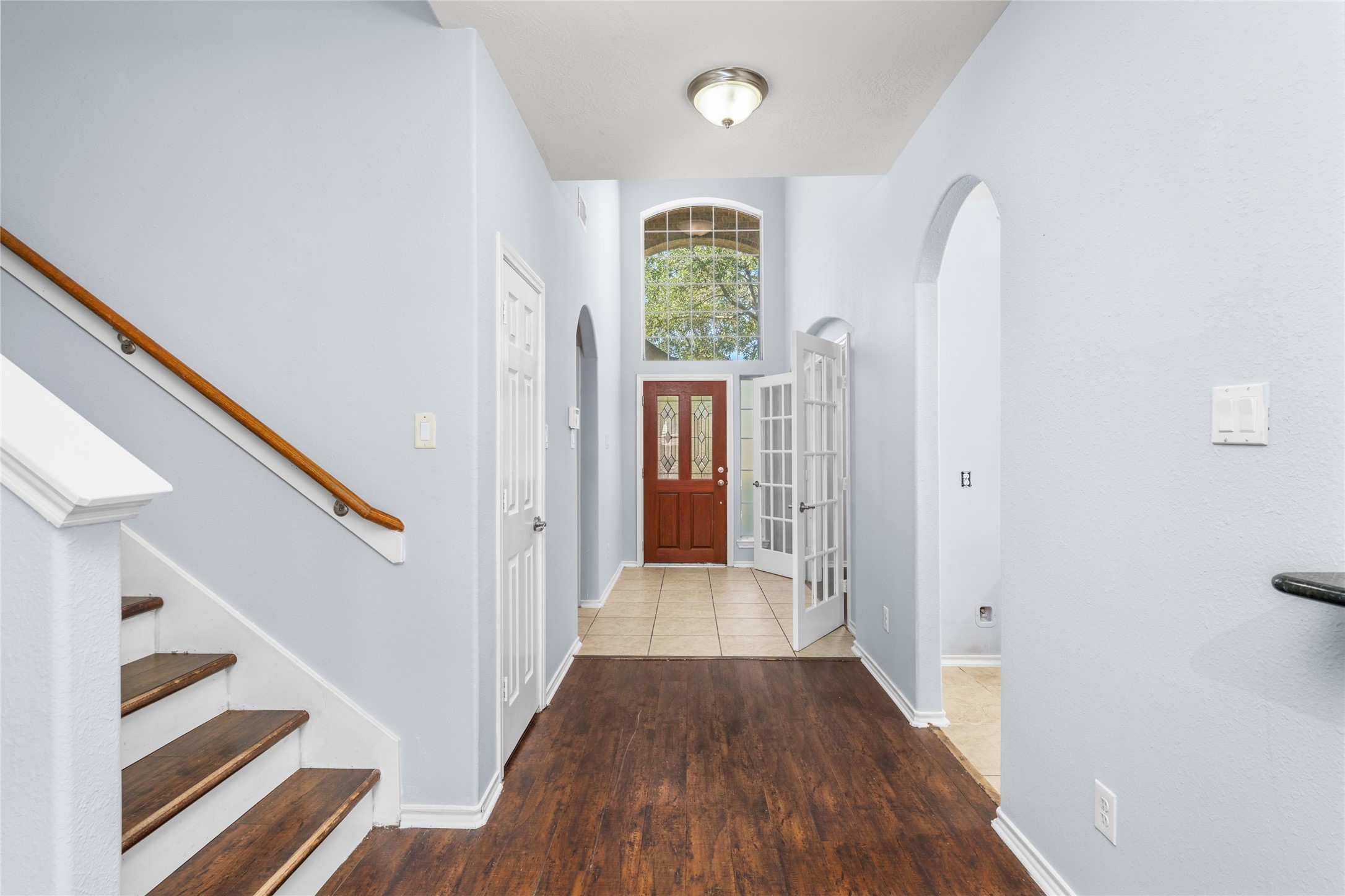 Bright two-story entryway featuring warm wood flooring, a tall window above the front door, and a staircase with a wood handrail. The open vertical space creates an inviting arrival and connects the home's main living areas. Bright two-story entryway featuring warm wood flooring, a tall window above the front door, and a staircase with a wood handrail. The open vertical space creates an inviting arrival and connects the home's main living areas.