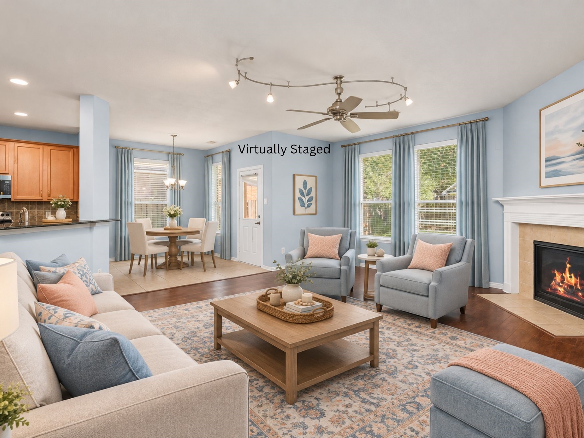 Virtually staged living room illustrating how the open space can accommodate a comfortable seating arrangement. The fireplace, wood flooring, and connection to the kitchen help create a welcoming setting for gathering with family and friends. Virtually staged living room illustrating how the open space can accommodate a comfortable seating arrangement. The fireplace, wood flooring, and connection to the kitchen help create a welcoming setting for gathering with family and friends.