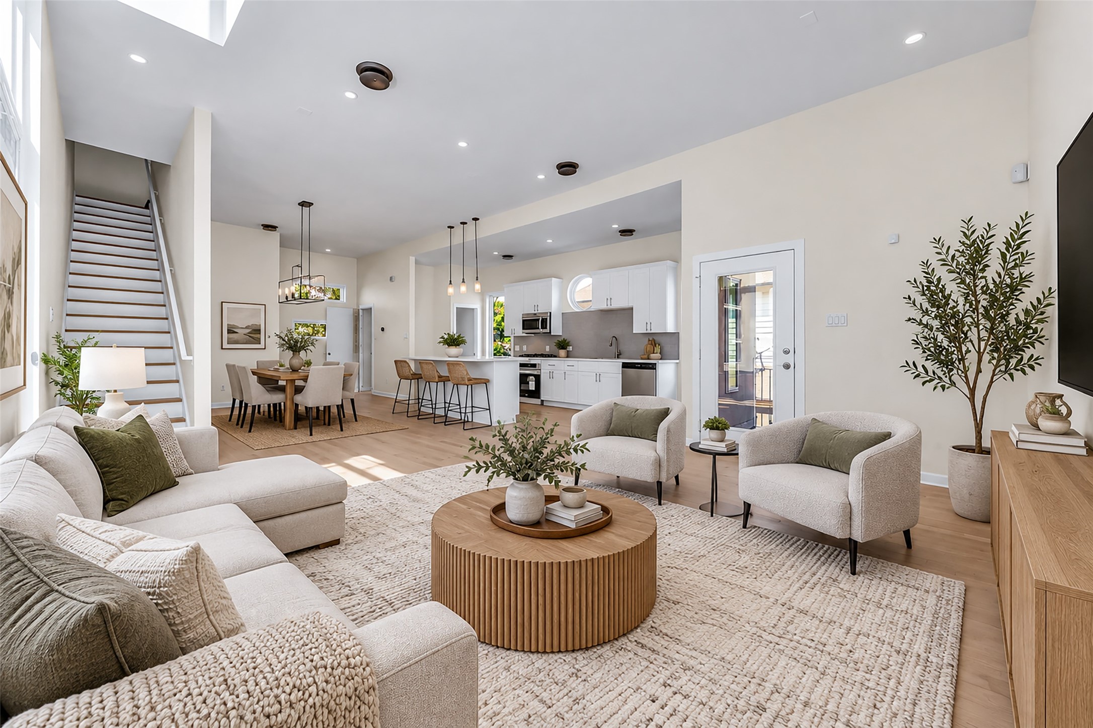 Virtually Staged. Bright and open living space with high ceilings, featuring a cozy seating area, modern kitchen with bar seating, and elegant dining area, perfect for entertaining.
