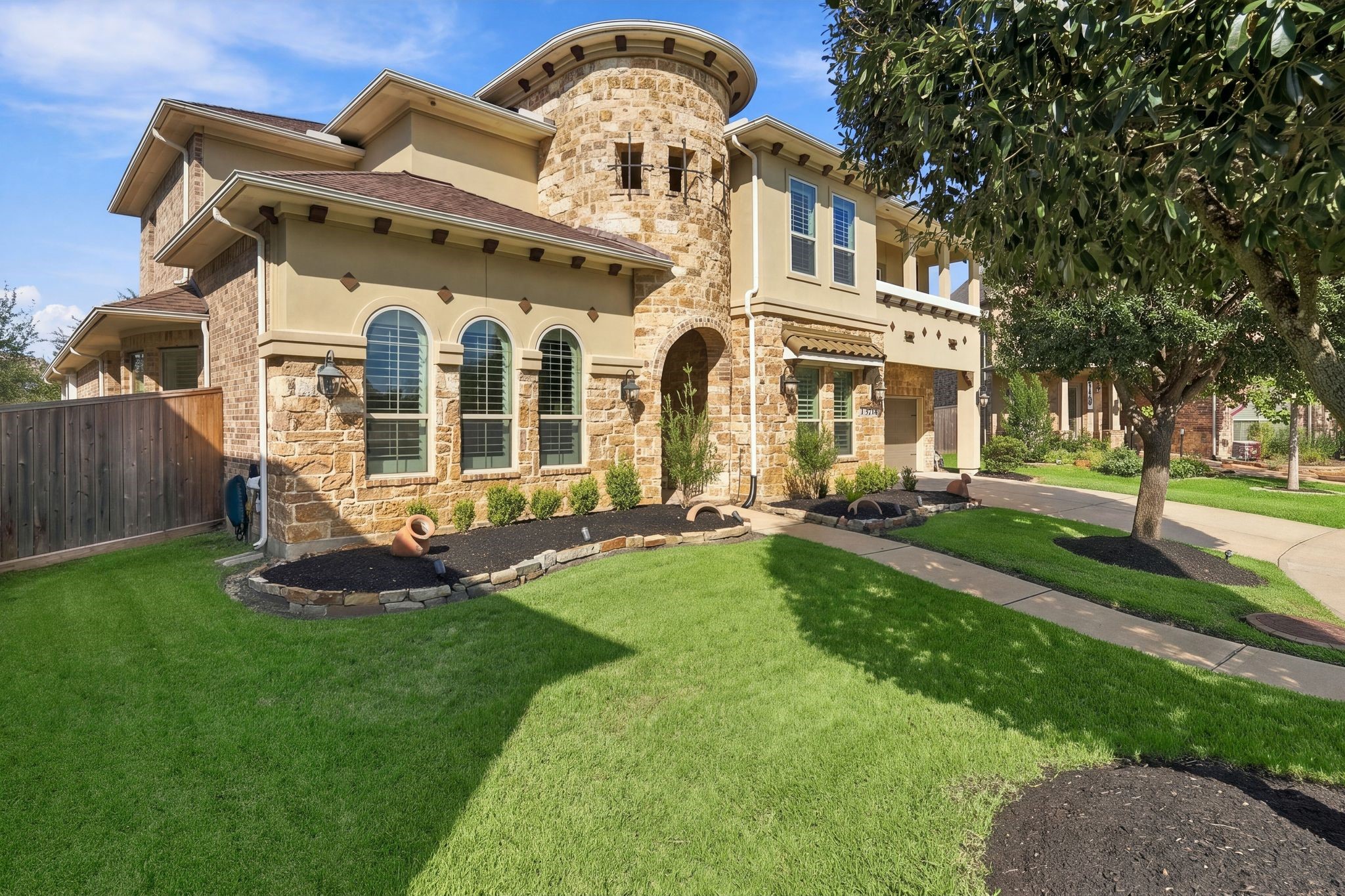 WOW FACTOR curb appeal! A stunning stone turret, grand arched entry, beautiful architectural details, and lush, manicured landscaping create an unforgettable first impression. This elegant luxury home in gated Wildwood at Northpointe offers timeless sophistication and exceptional pride of ownership!