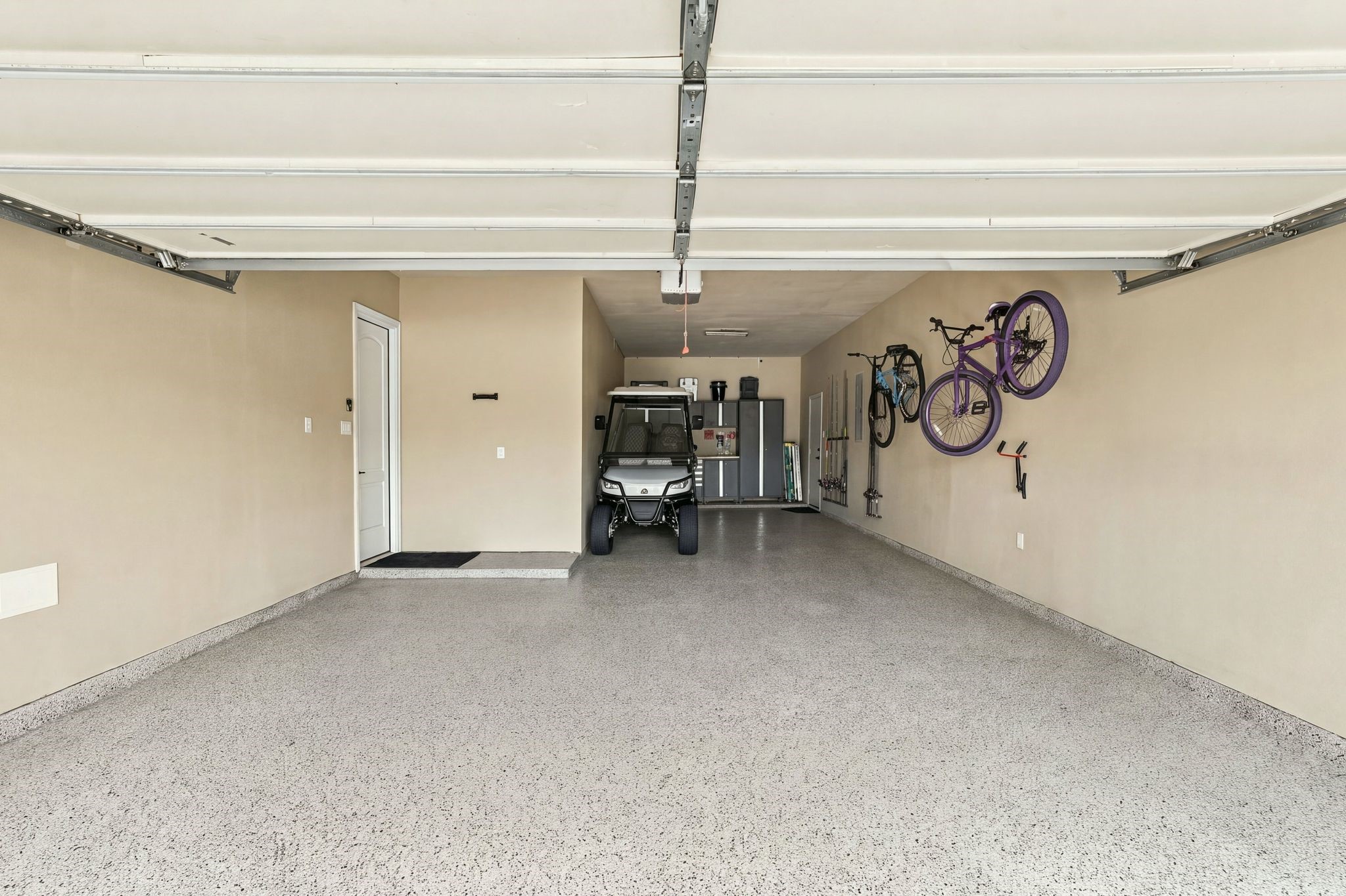 Spacious 3-car tandem garage featuring durable epoxy flooring, overhead storage, wall-mounted organization, and a dedicated workspace. Impressive depth and generous floor space provide exceptional flexibility for multiple vehicles, recreational equipment, and additional storage.