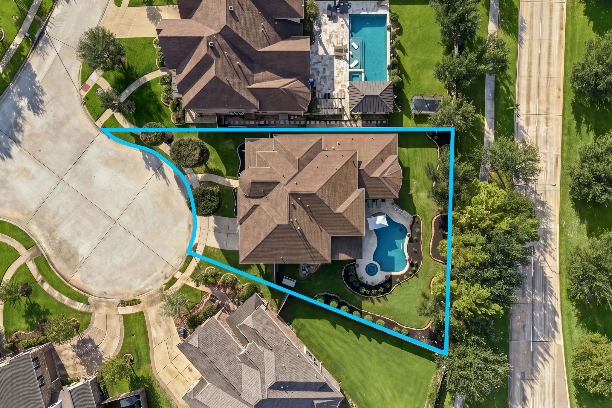 Impressive aerial view highlights the home's spacious cul-de-sac lot, beautifully landscaped grounds, custom resort-style pool and spa, and generous backyard green space.
