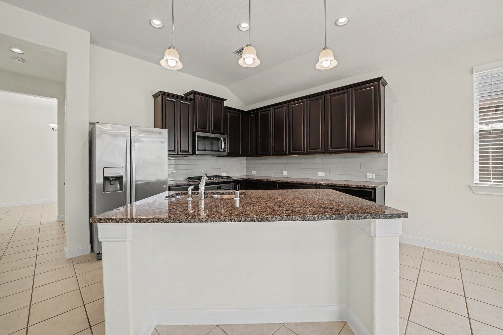 View of the kitchen island, with access to the formal dining room, pantry and a doorway leading to the oversize laundry room