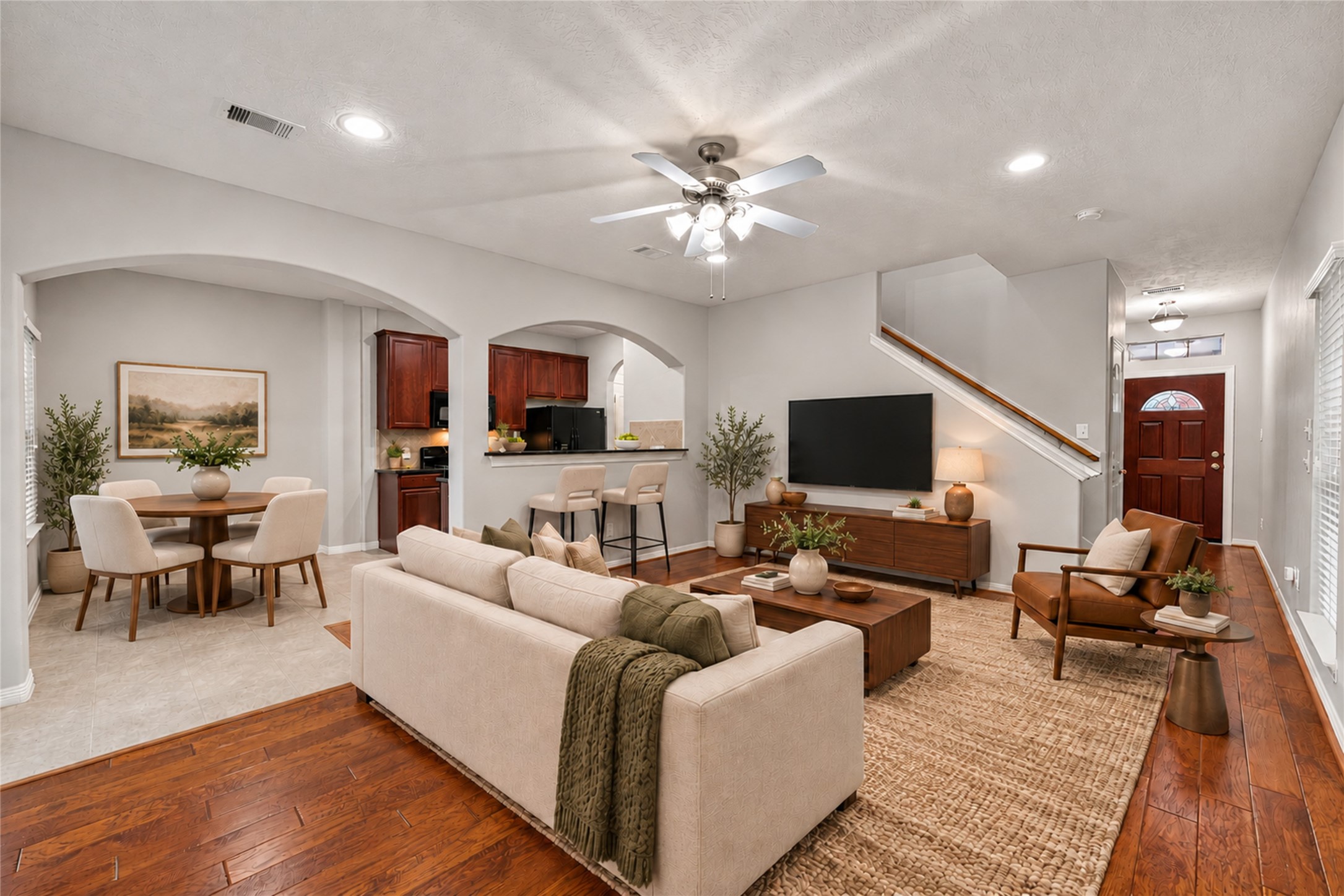 Virtually staged living room open to kitchen and dining area.