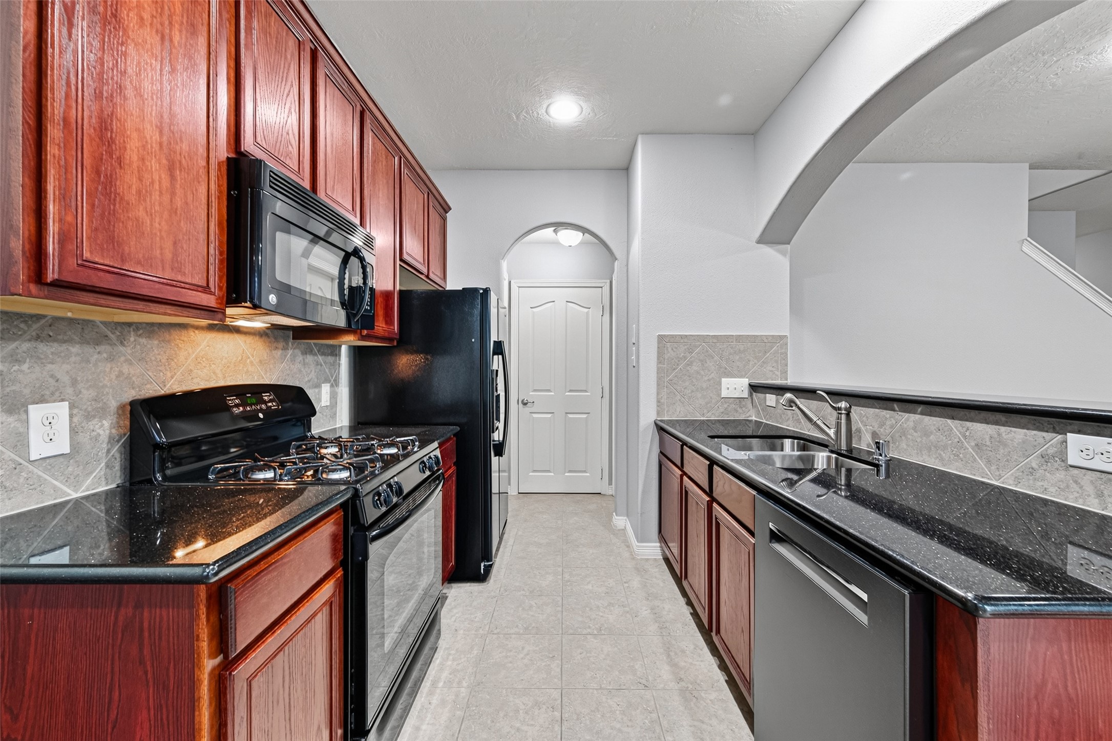 There are three doors at the end of the kitchen:  pantry, garage, half bath.