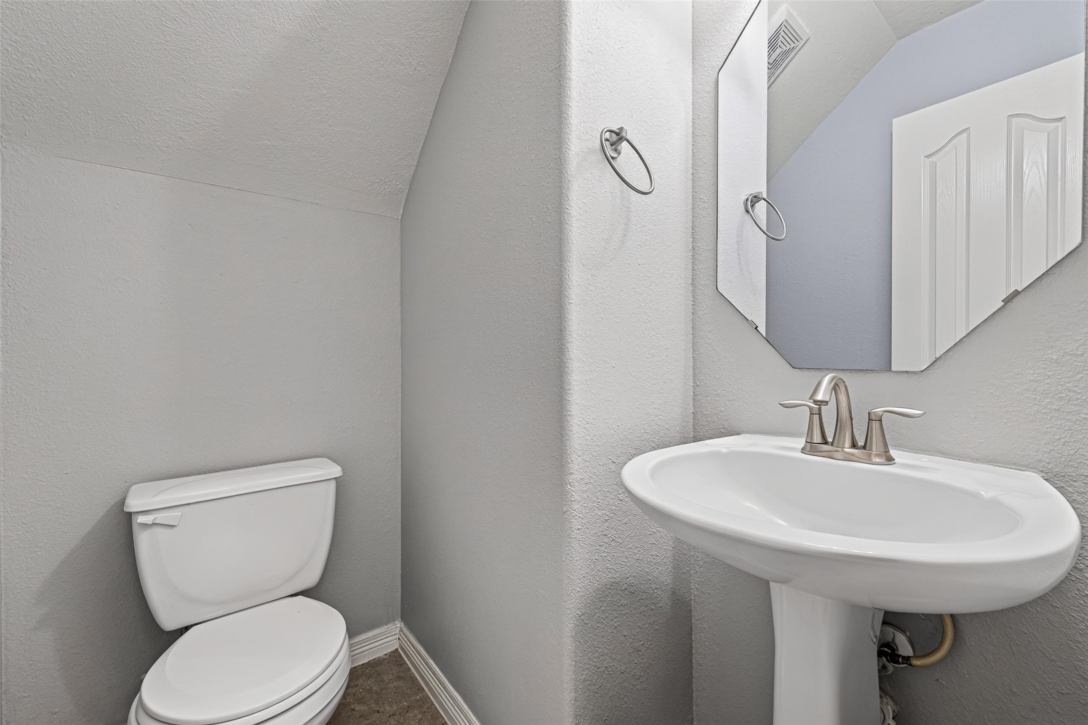 Half bath near entrance to garage.