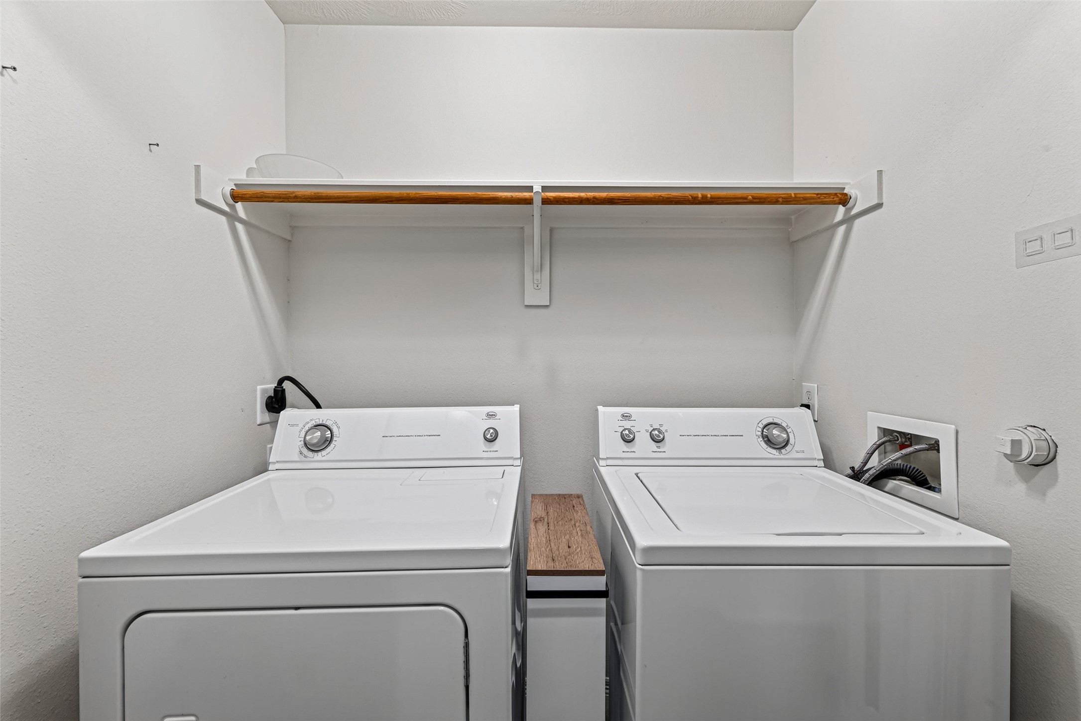Laundry with washer and dryer, shelves, and hanging rod is upstairs near the bedrooms.