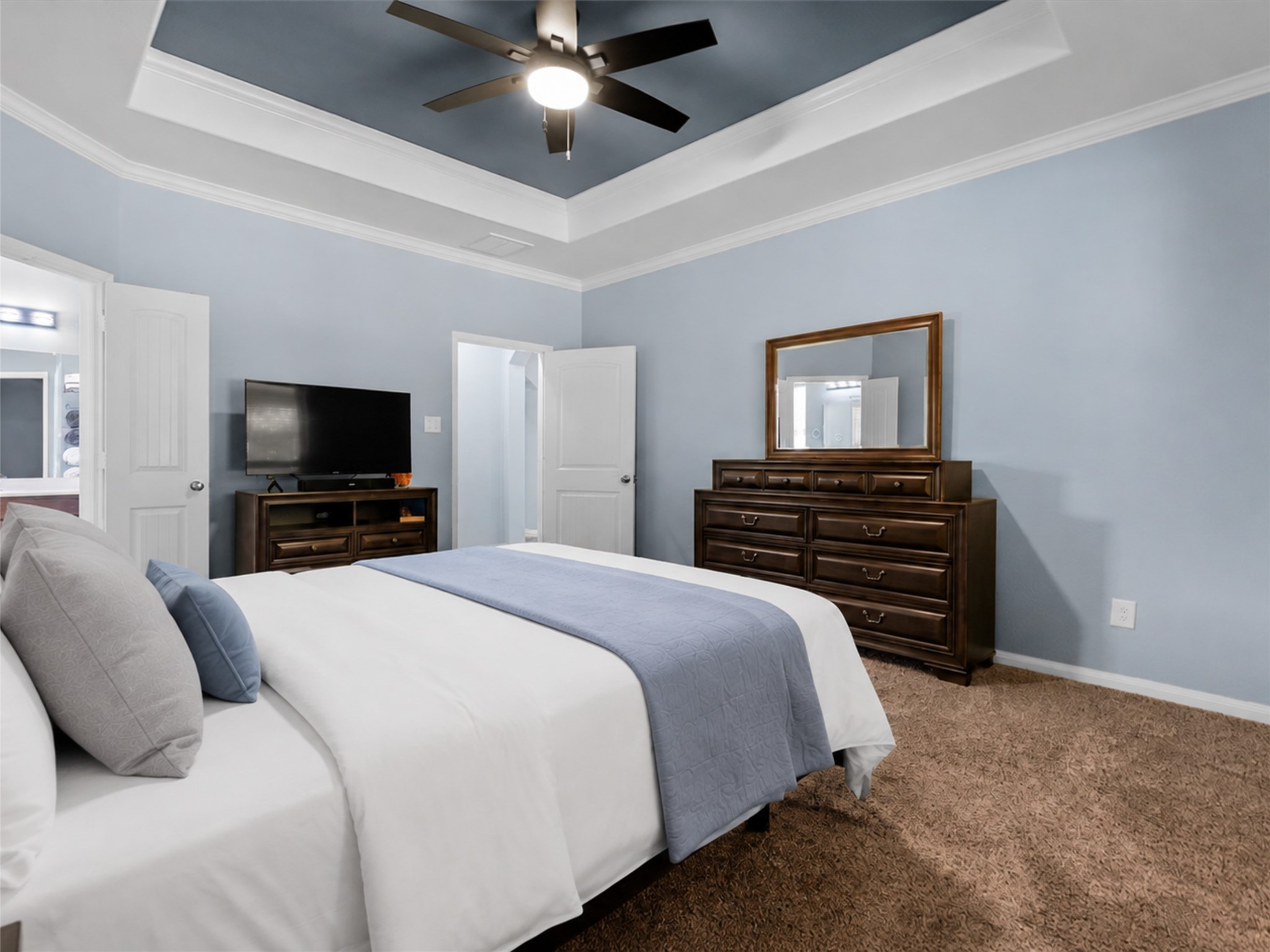 Another view of the primary bedroom highlights the generous space and comfortable, calming atmosphere.