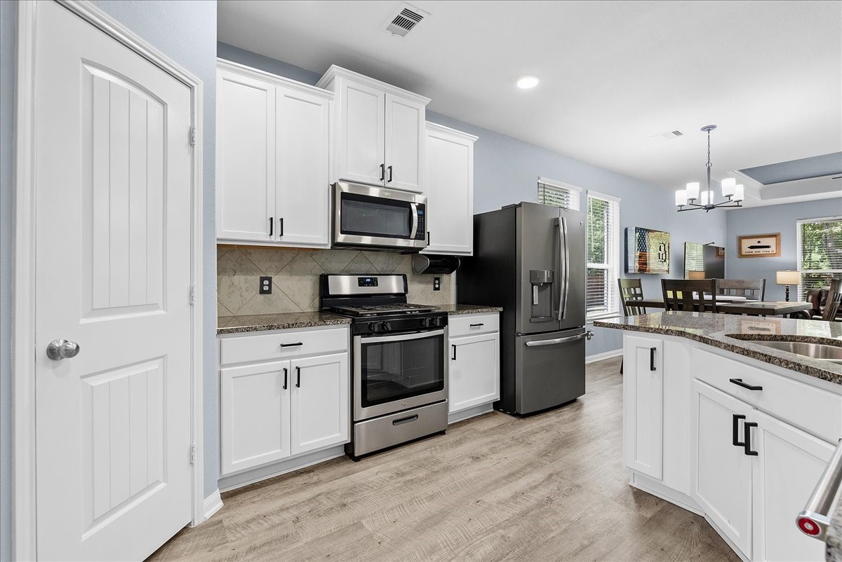Bright kitchen features granite countertops, crisp cabinetry, stainless appliances and plenty of workspace.