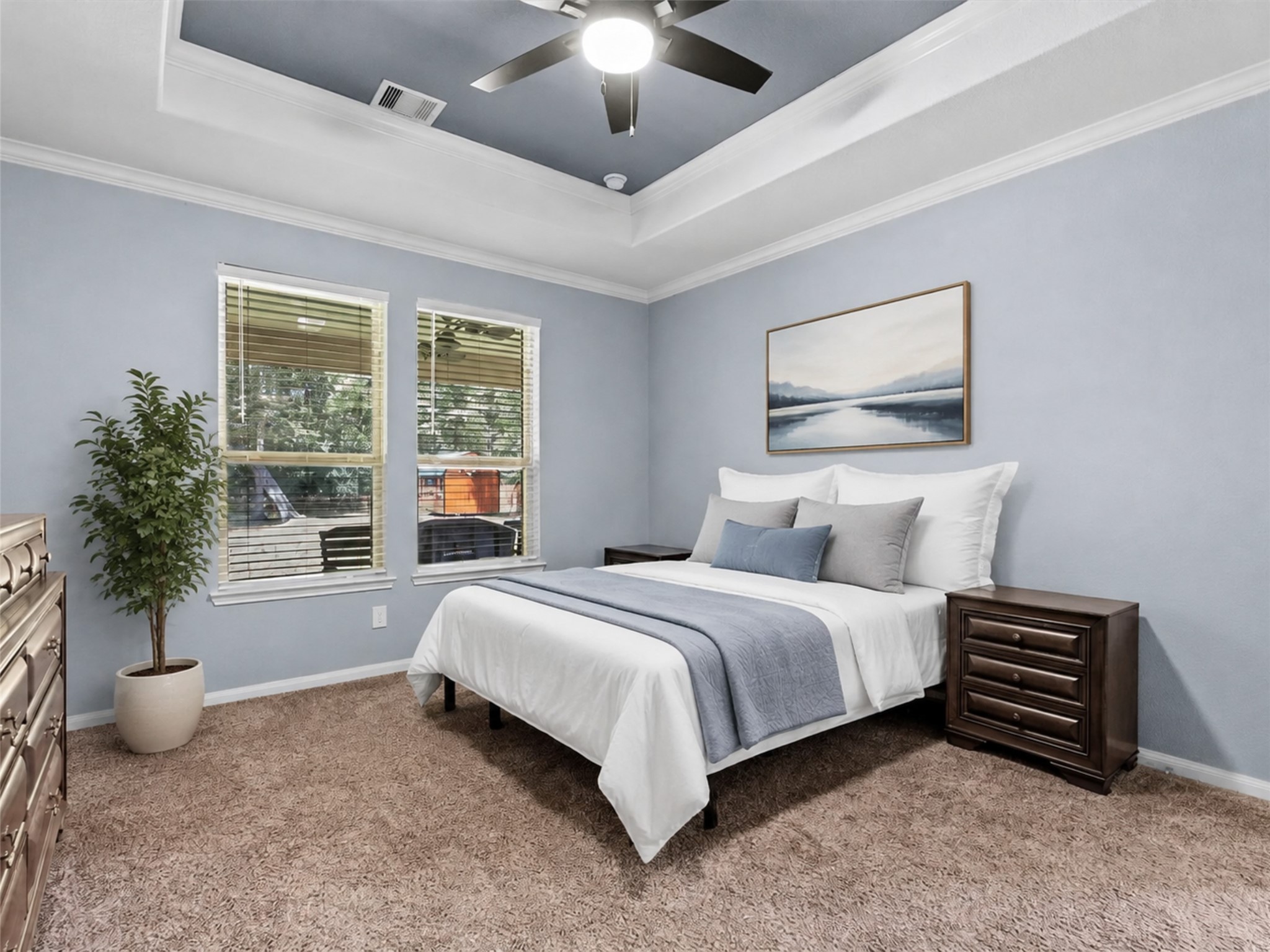 Retreat to the spacious first-floor primary suite featuring a tray ceiling, fresh paint and peaceful natural light.