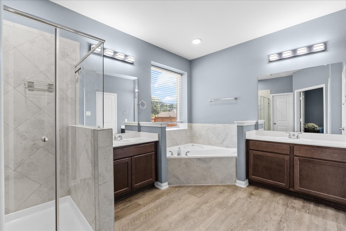 Spacious primary bath features dual vanities, a soaking tub and separate shower for a relaxing start or end to your day.