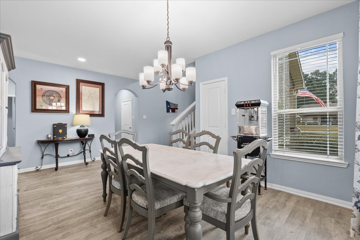 Large windows fill the dining area with natural light while vinyl plank flooring keeps the space fresh and inviting.