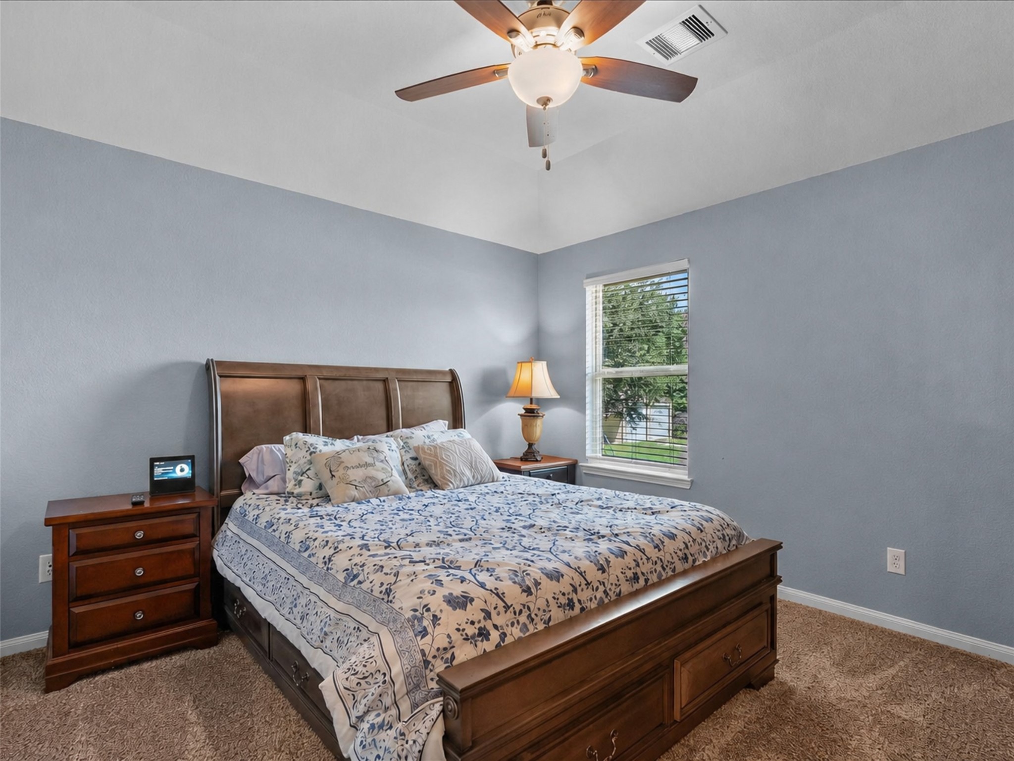 Comfortable secondary bedroom with fresh paint, soft carpet and a ceiling fan for added comfort.