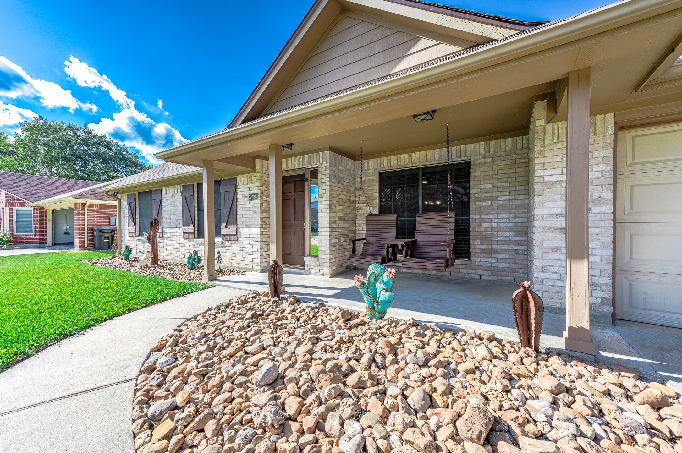 Charming home with a welcoming front porch, featuring a cozy swing and beautifully landscaped rock garden, perfect for relaxation and curb appeal. Charming home with a welcoming front porch, featuring a cozy swing and beautifully landscaped rock garden, perfect for relaxation and curb appeal.