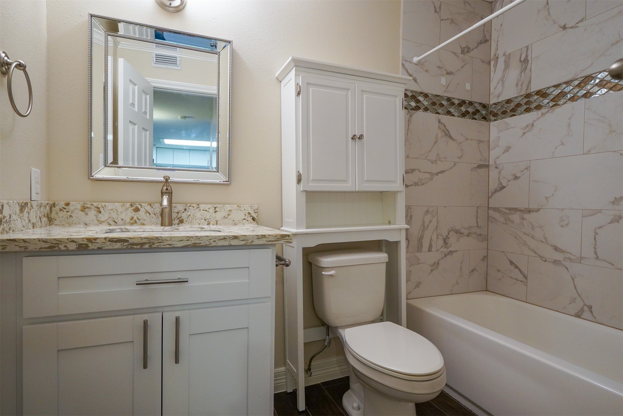 Like new bathroom with tiles,accents, tall cabinet and granite