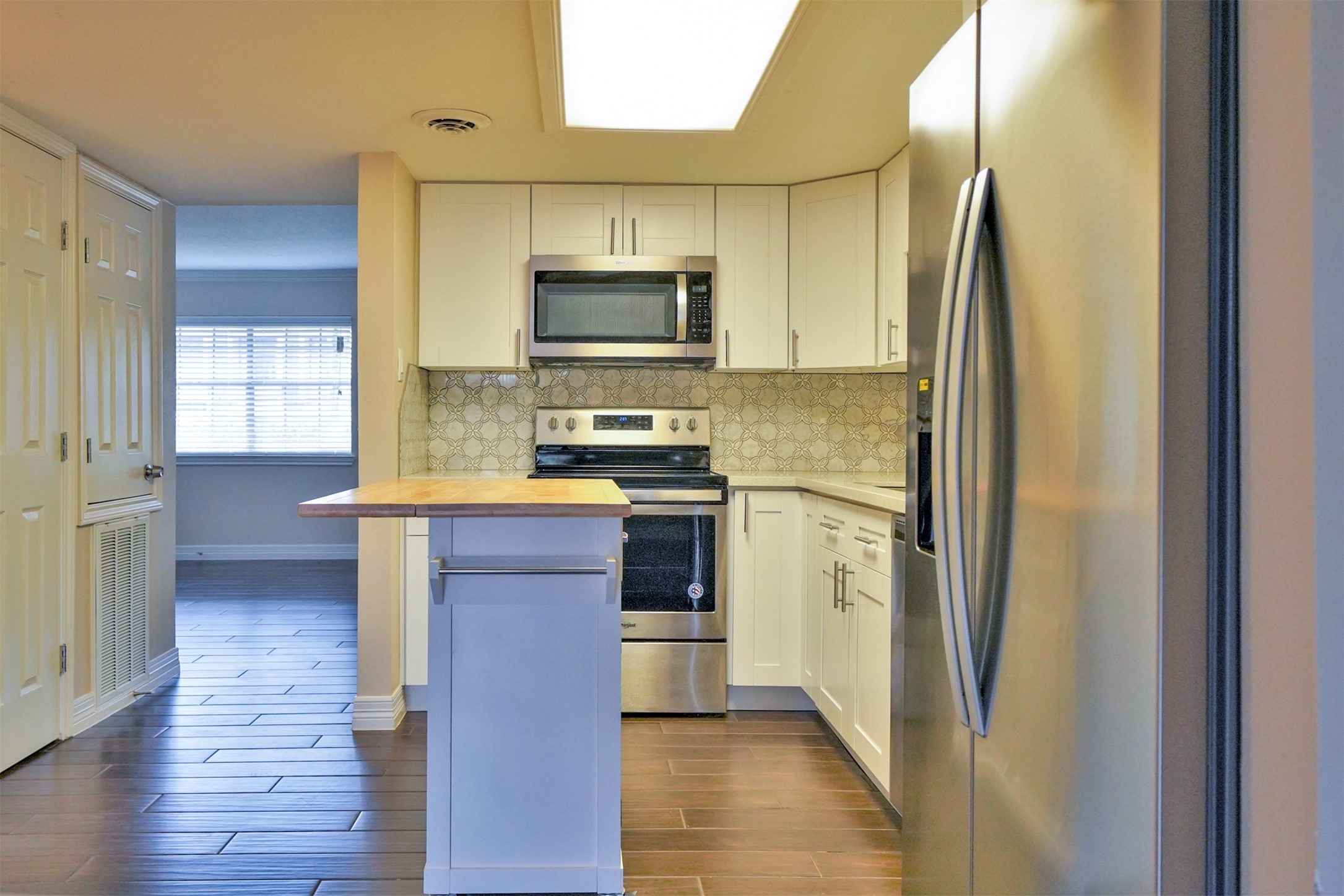 Kitchen opens to both living & den rooms... island on wheels