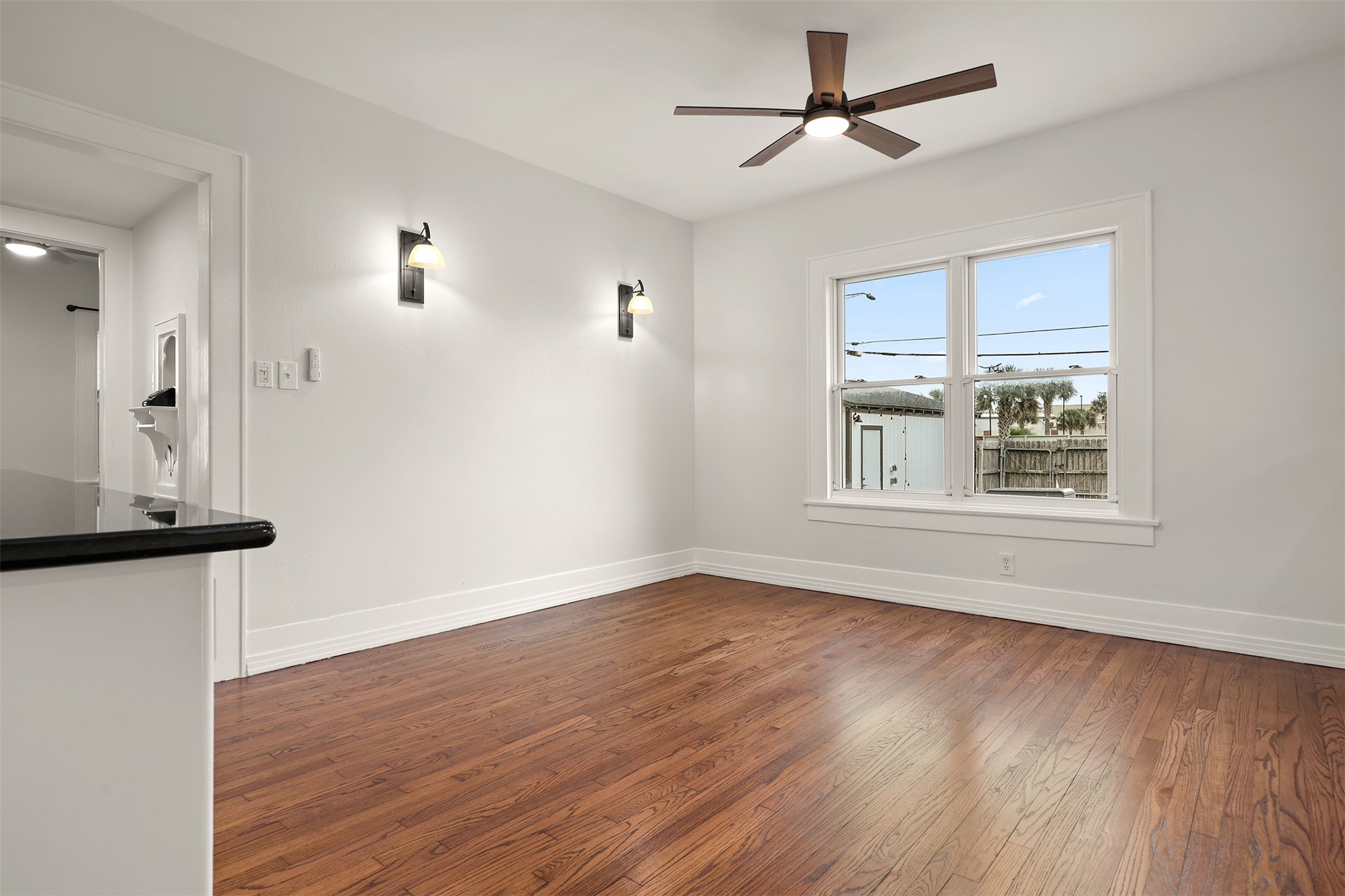 Bright and airy dining room with large windows overlooking the backyard.