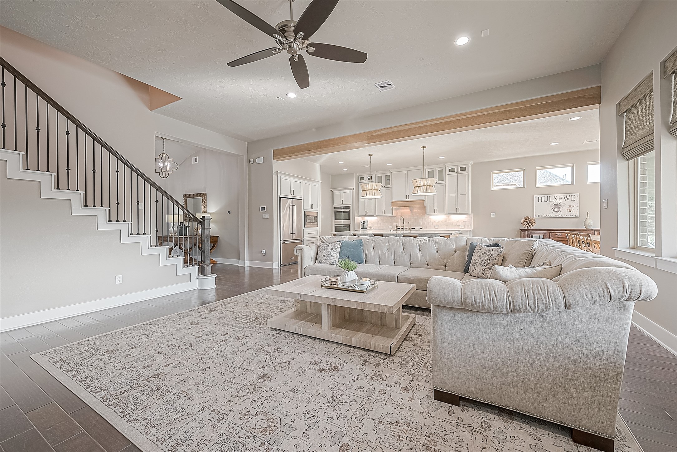 The view of the open-concept living and kitchen area is separated by the newly added warm wood beam.