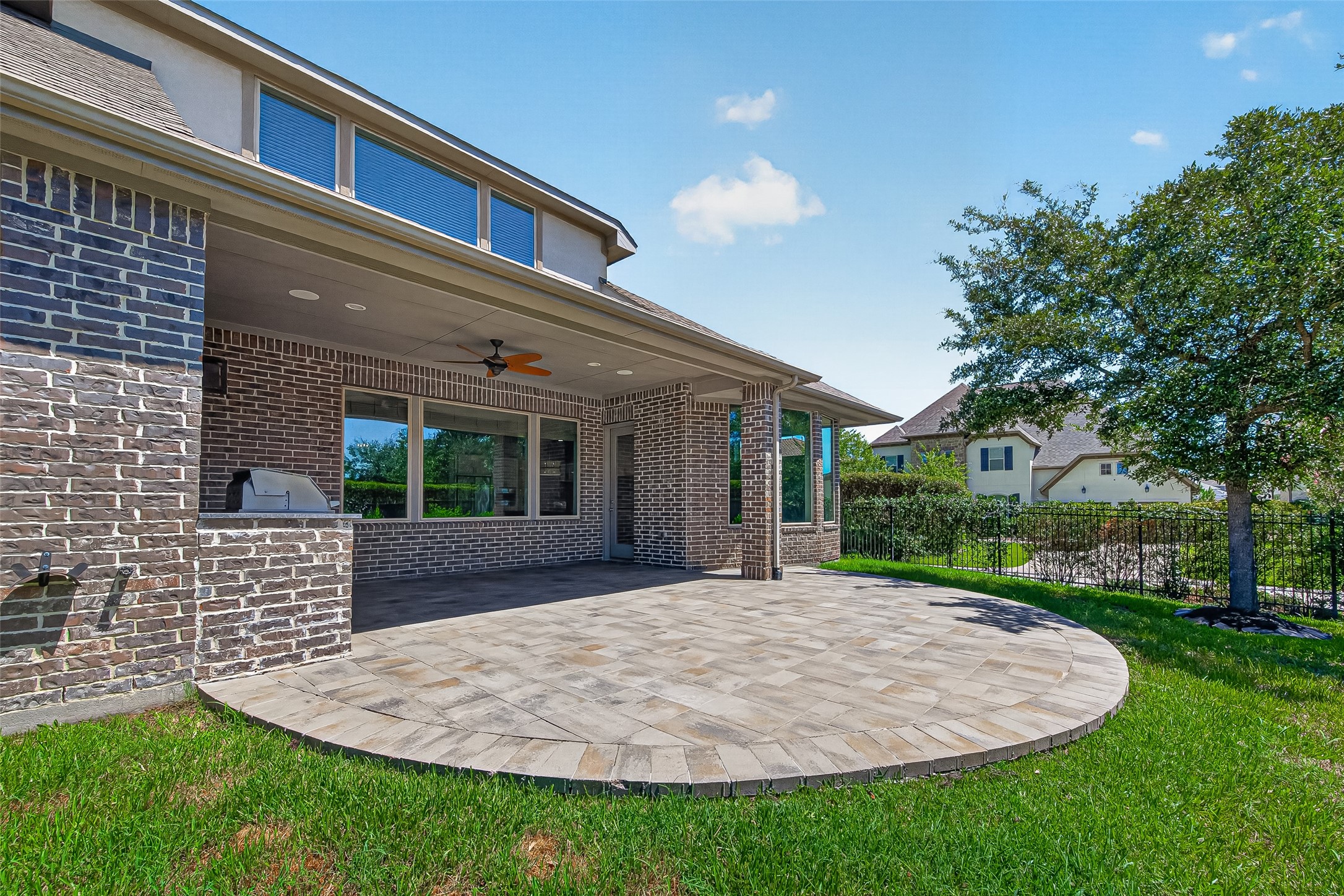 Beautiful covered back patio with ceiling fan and outdoor kitchen.
